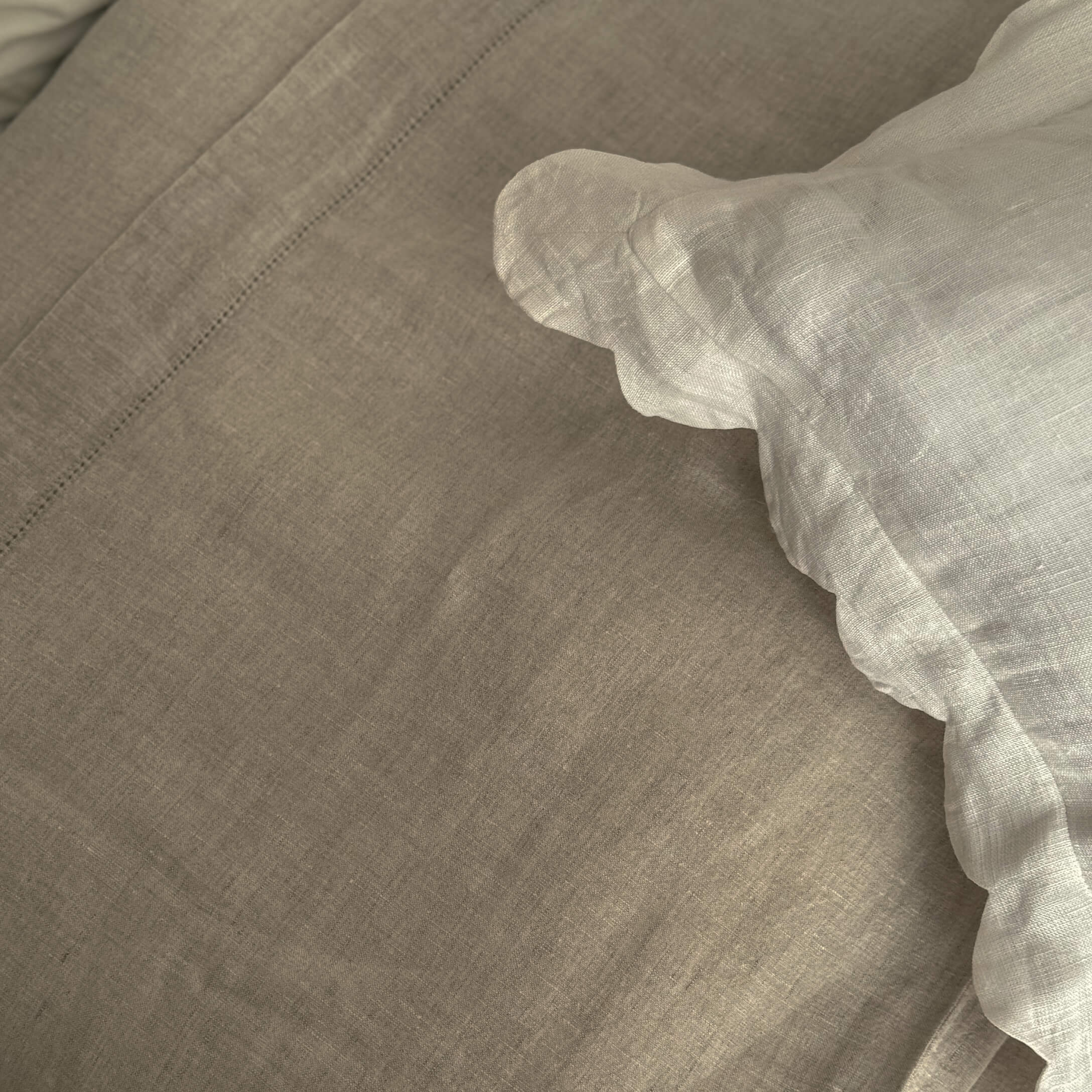 Beige Leinenbettwäsche mit weißem Rüschensaum, natürliche Stoffqualität für gemütliches Schlafzimmer