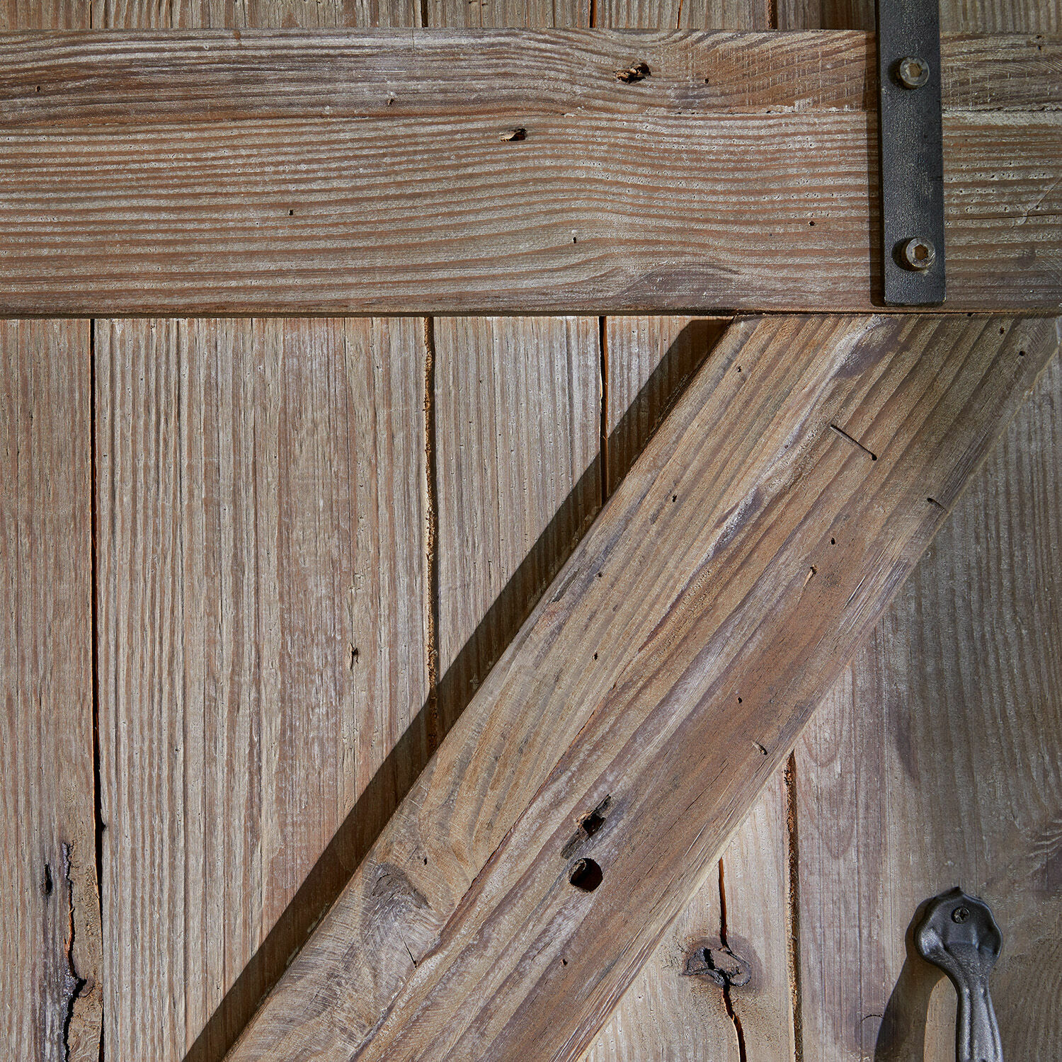 Rustikale Holztür in Naturholz mit Metallgriff und Metallverstärkung für Landhausstil