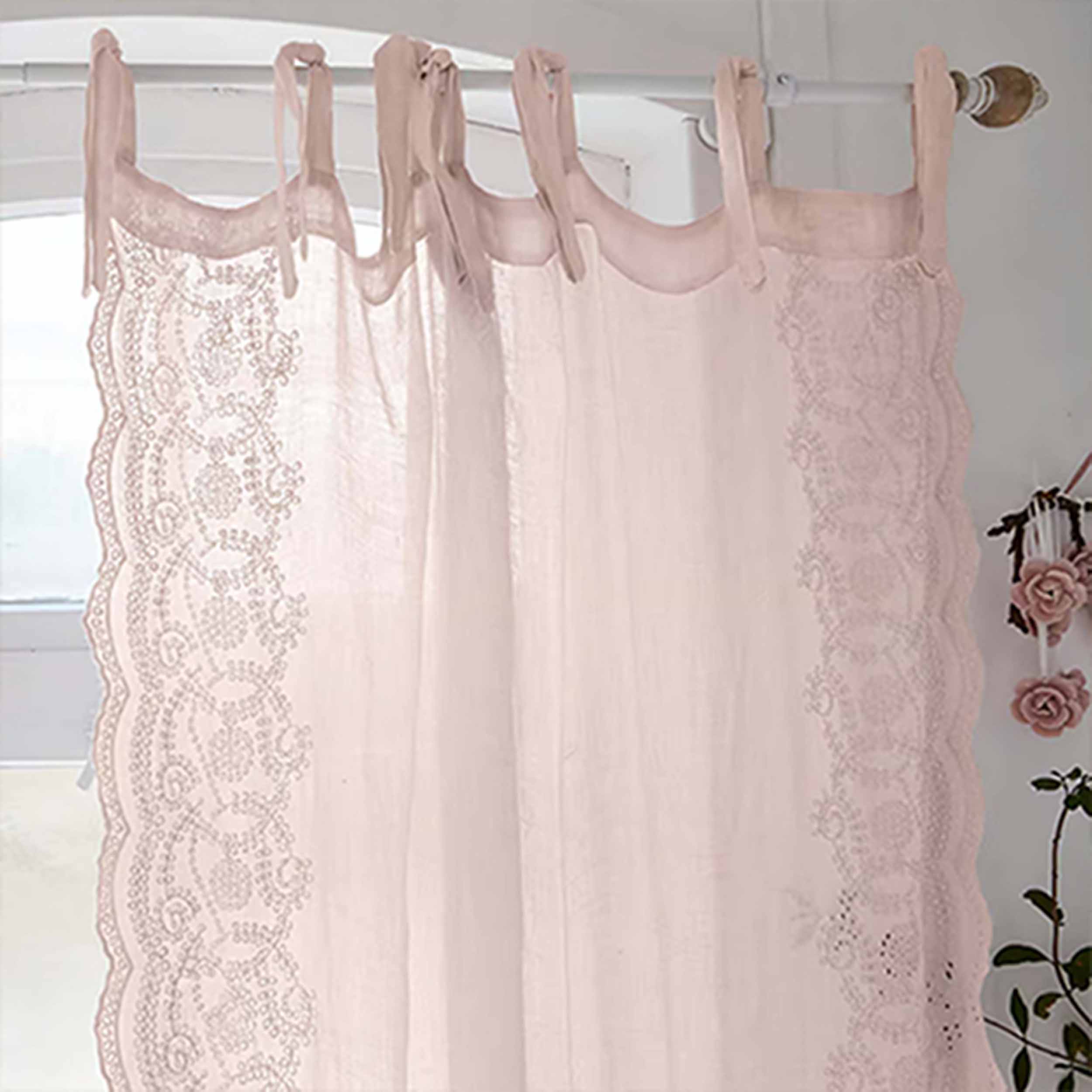 Rosa Duschvorhang aus Textil mit Spitzenmuster an weißer Stange aufgehängt