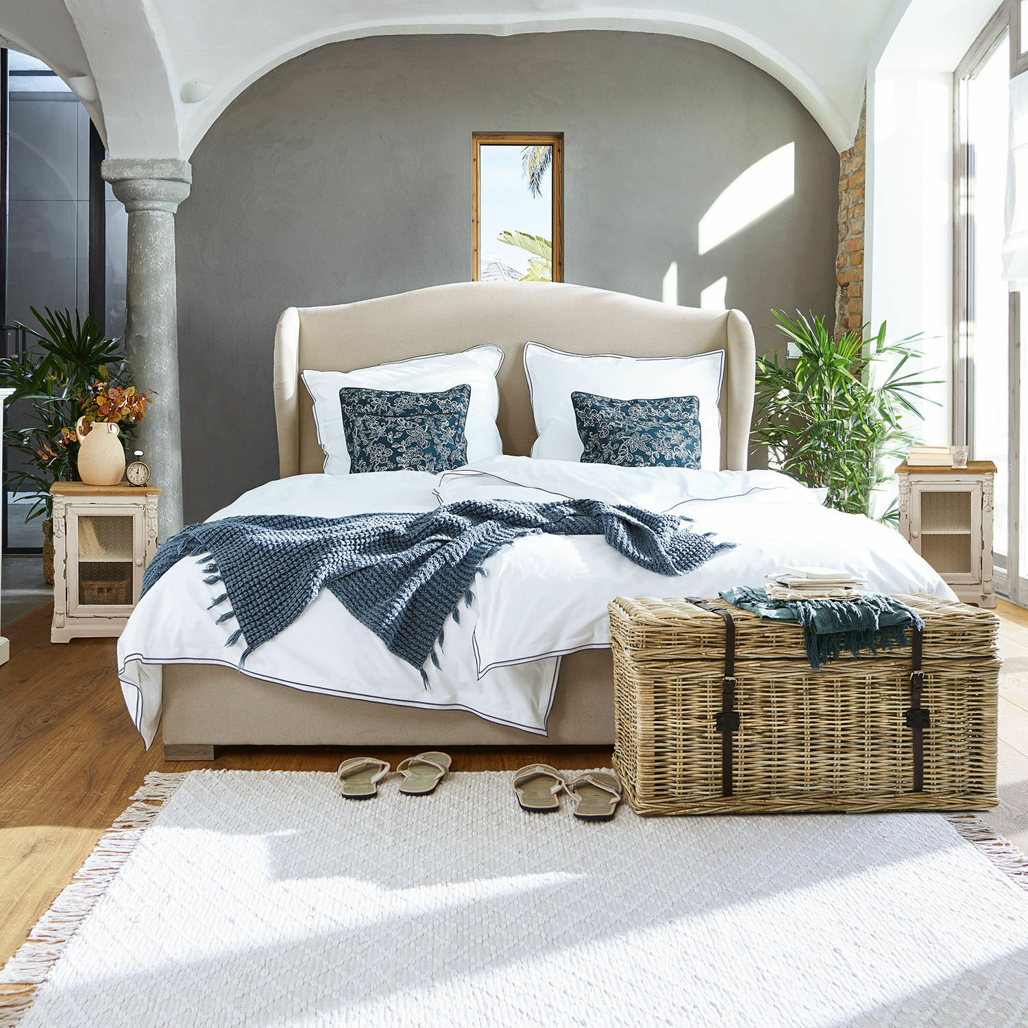Beiges Polsterbett mit weißer Bettwäsche und blauem Plaid in hellem, modernem Schlafzimmer