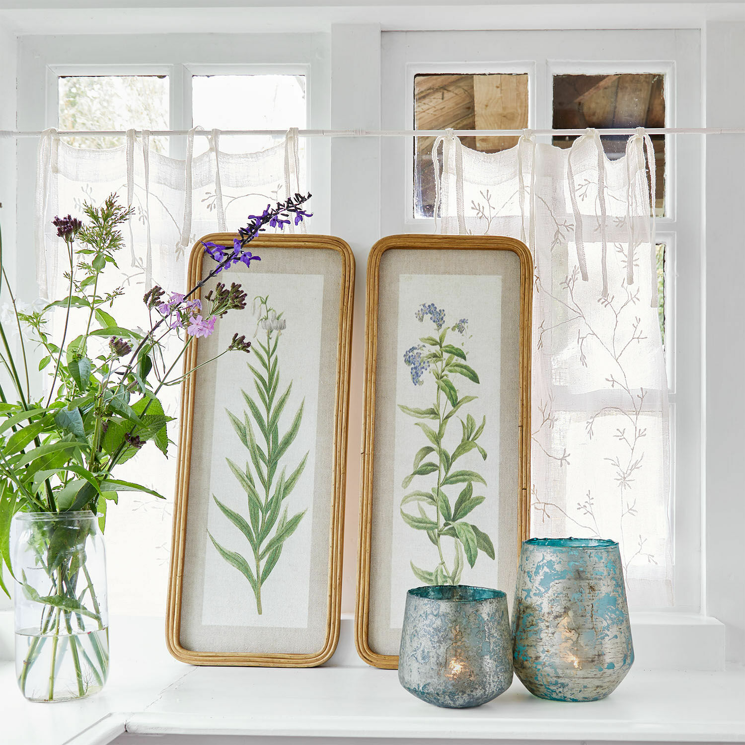 Bild 2er Set Cenori Zwei Holzrahmen mit botanischen Pflanzenillustrationen auf weißem Fensterbrett mit blauen Dekokerzenhaltern