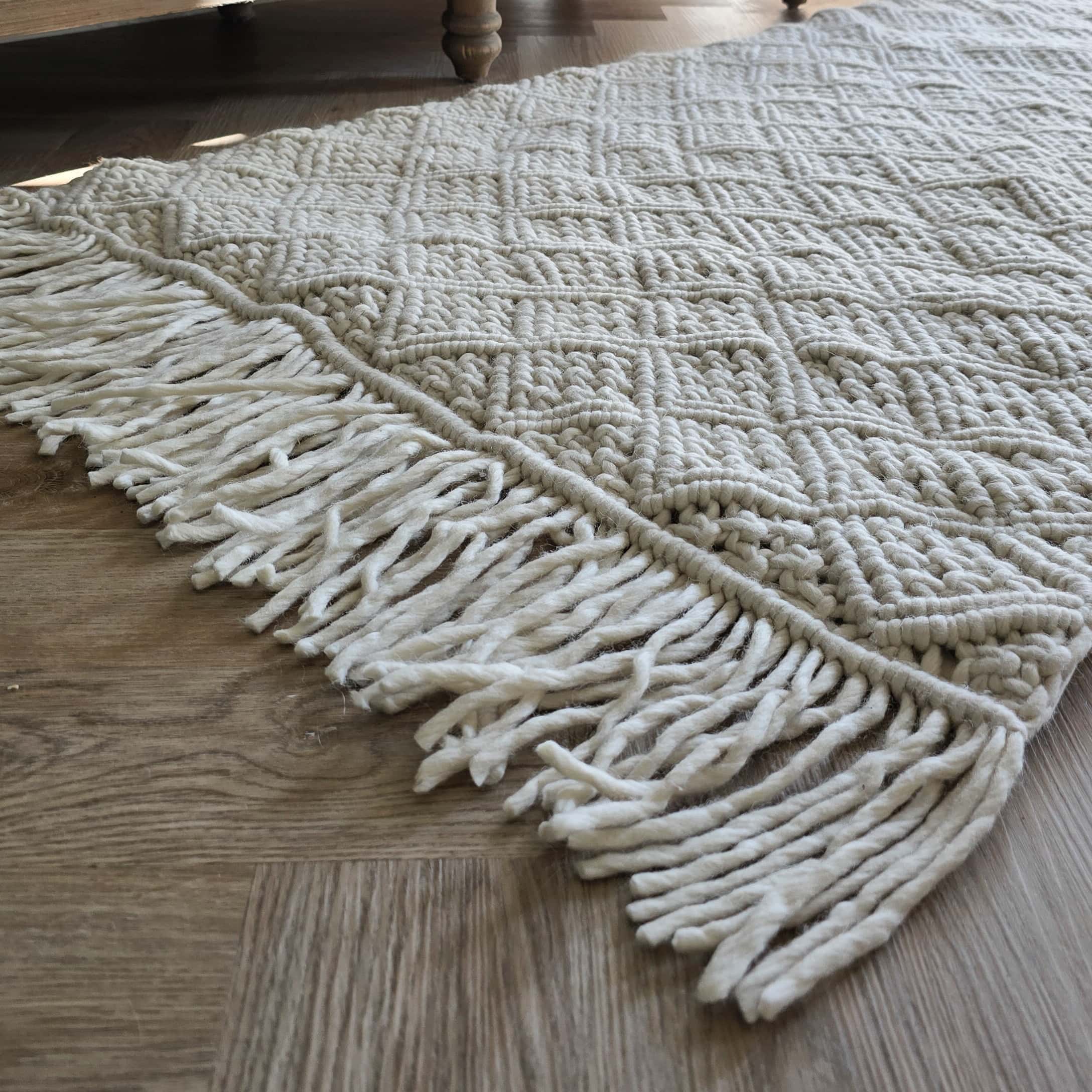 Weißer Teppich mit grobem Muster und Fransen auf Holzboden, weiches dekoratives Material