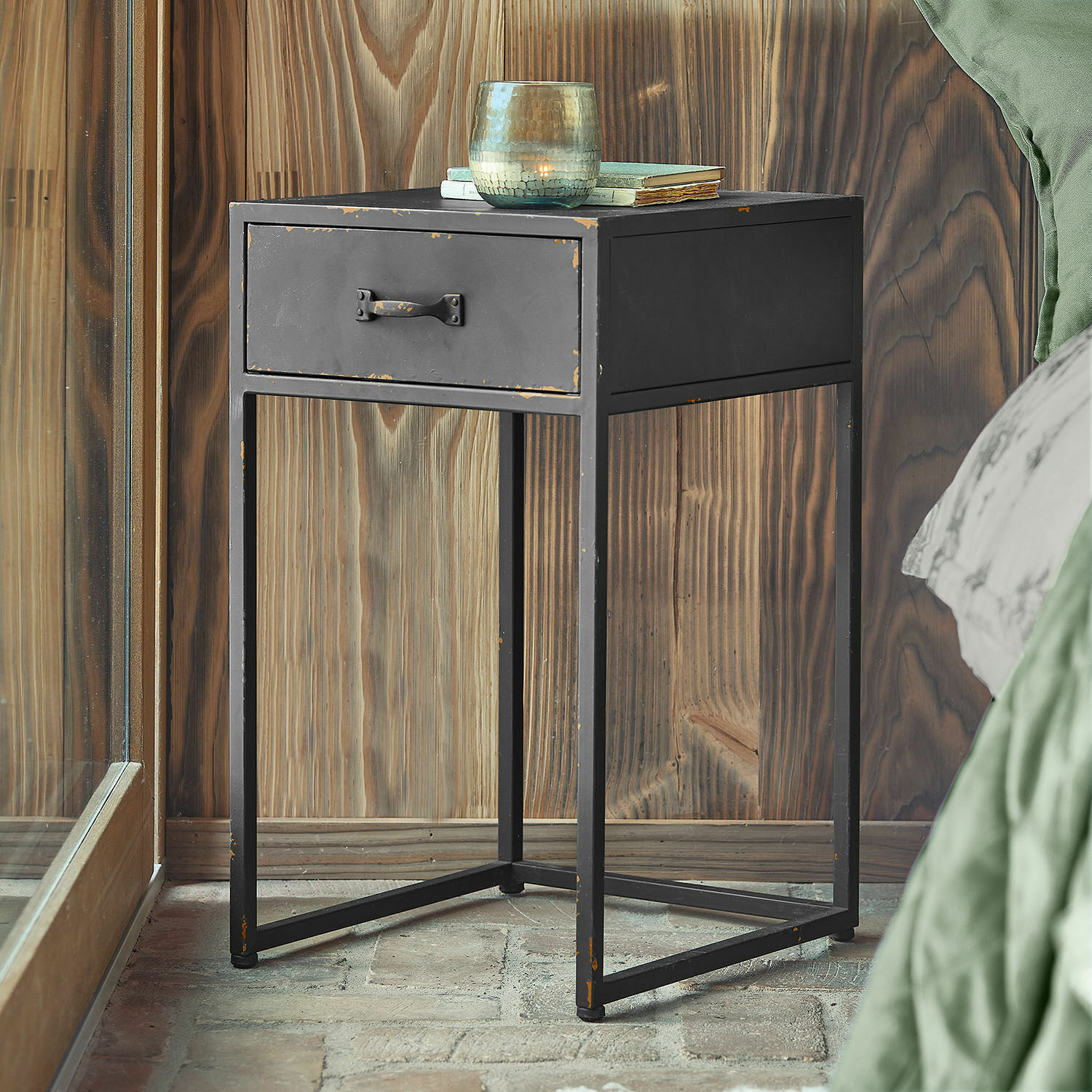 Schwarzer Metall-Nachttisch mit Schublade im Industrie-Design vor Holzwand
