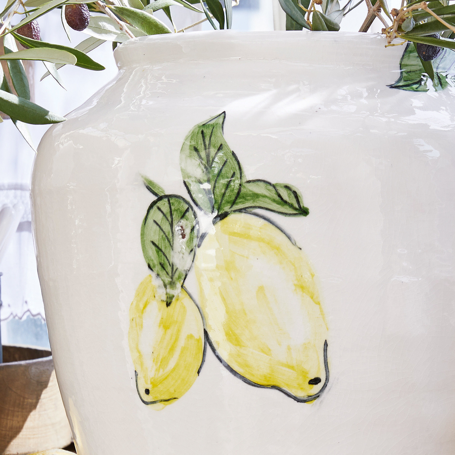 Weiße Keramikvase mit handbemalten gelben Zitronen und grünen Blättern als Wohnaccessoire