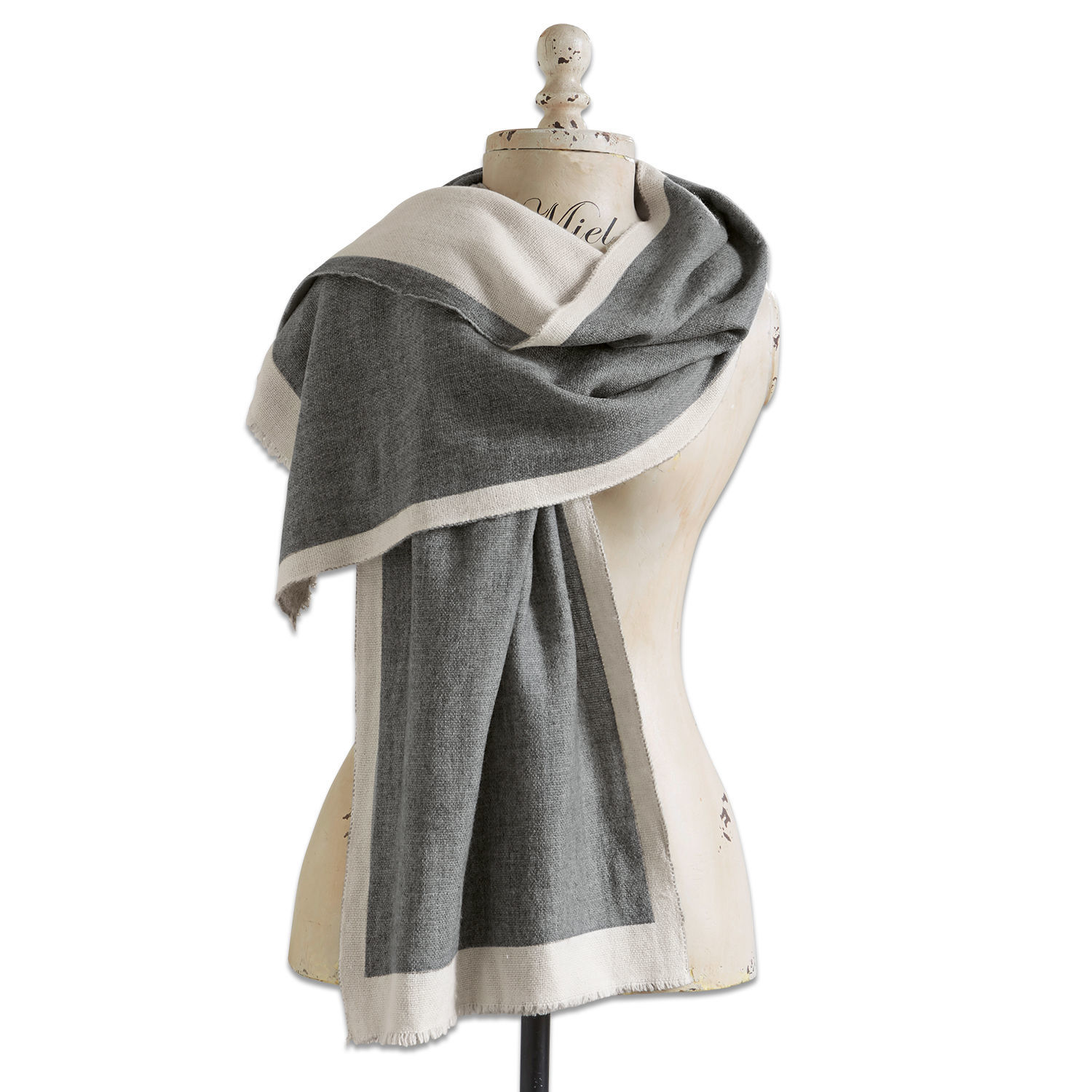 Grauer Schal mit beigem Rand auf Schneiderpuppe, weiches Material, modisches Accessoire