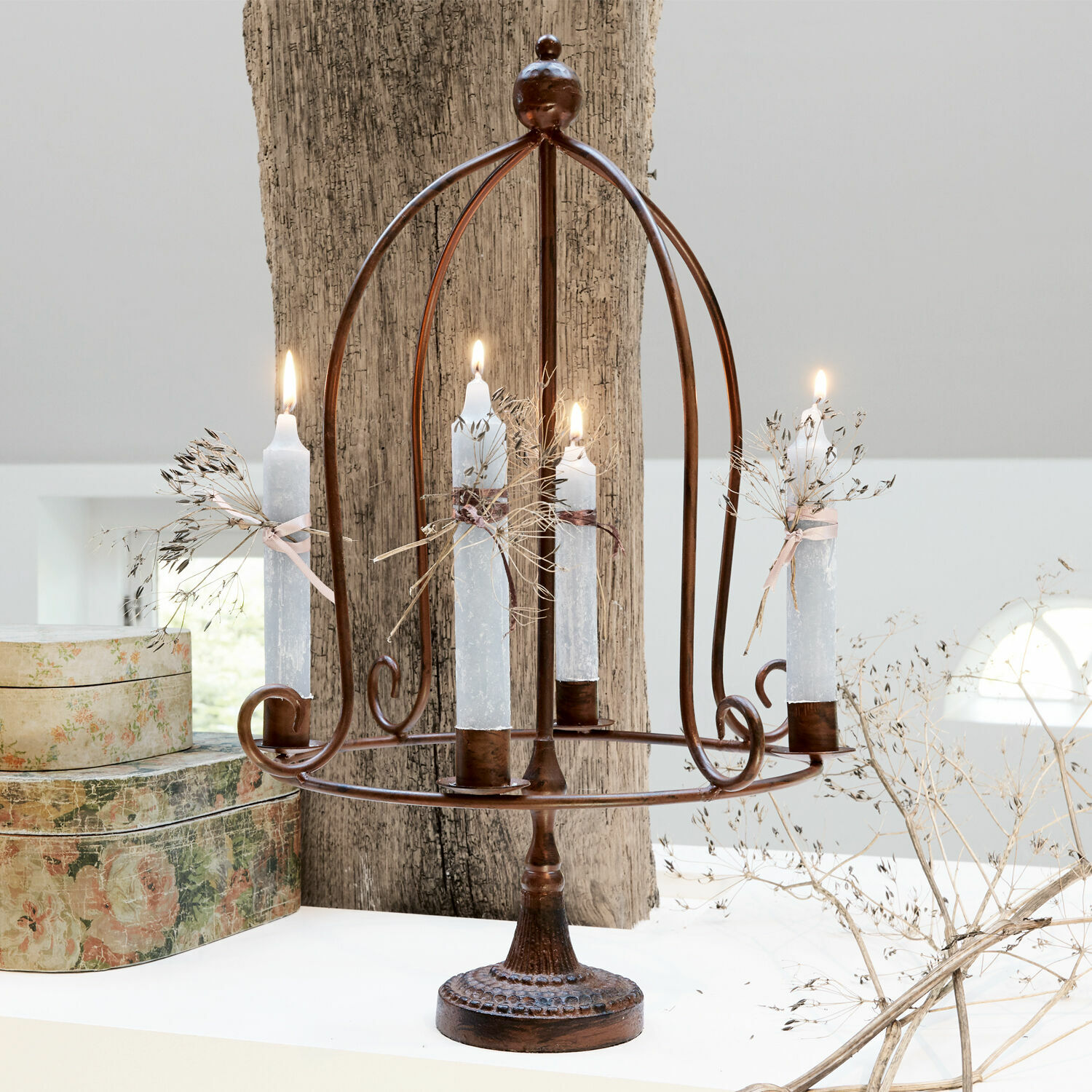 Kerzenhalter Majura Metall-Kerzenhalter in Rostoptik mit vier weißen Kerzen und getrockneten Pflanzen als Dekor