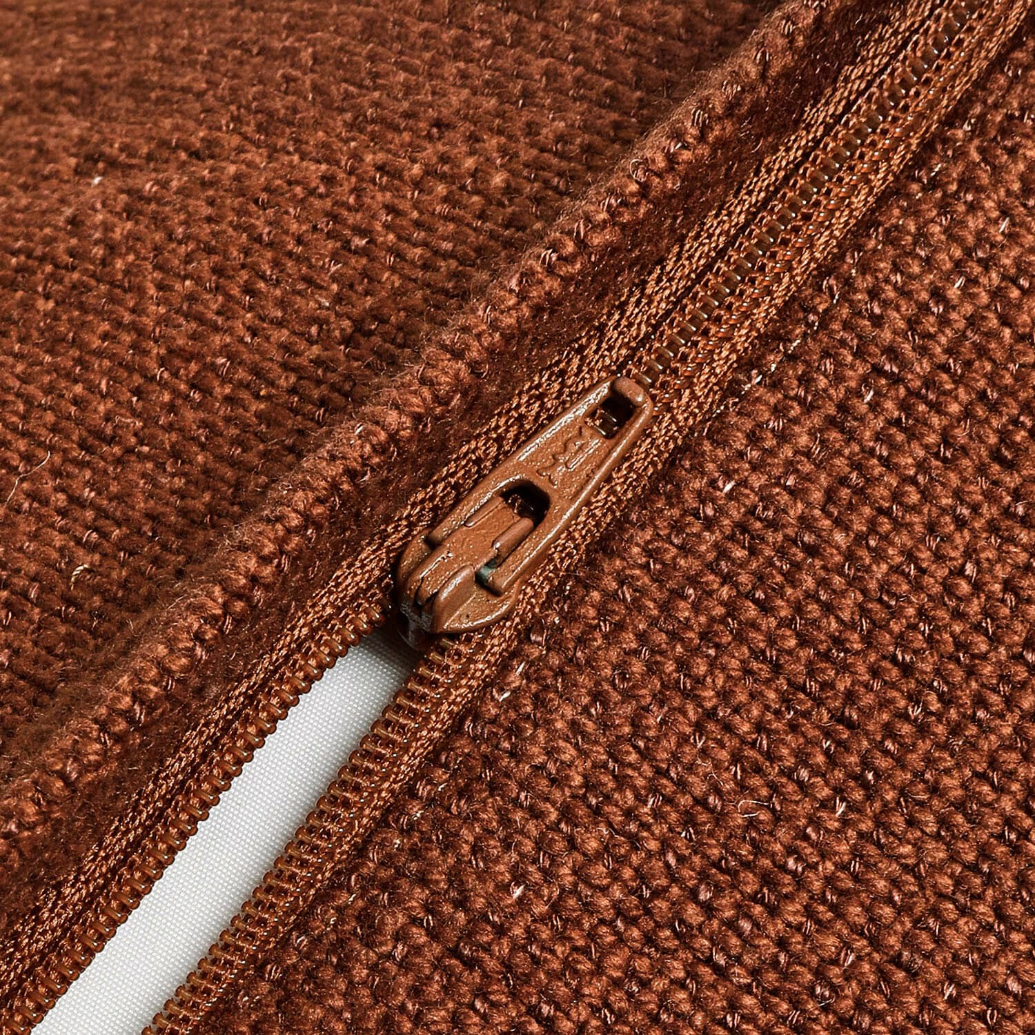 Nahaufnahme eines braunen Reißverschlusses und der groben Strickstoffstruktur