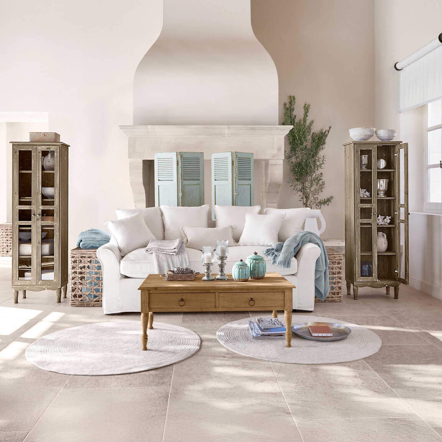 Gemütliches Wohnzimmer mit weißem Sofa, Holzcouchtisch und zwei antiken Holzvitrinen im Vintage-Stil