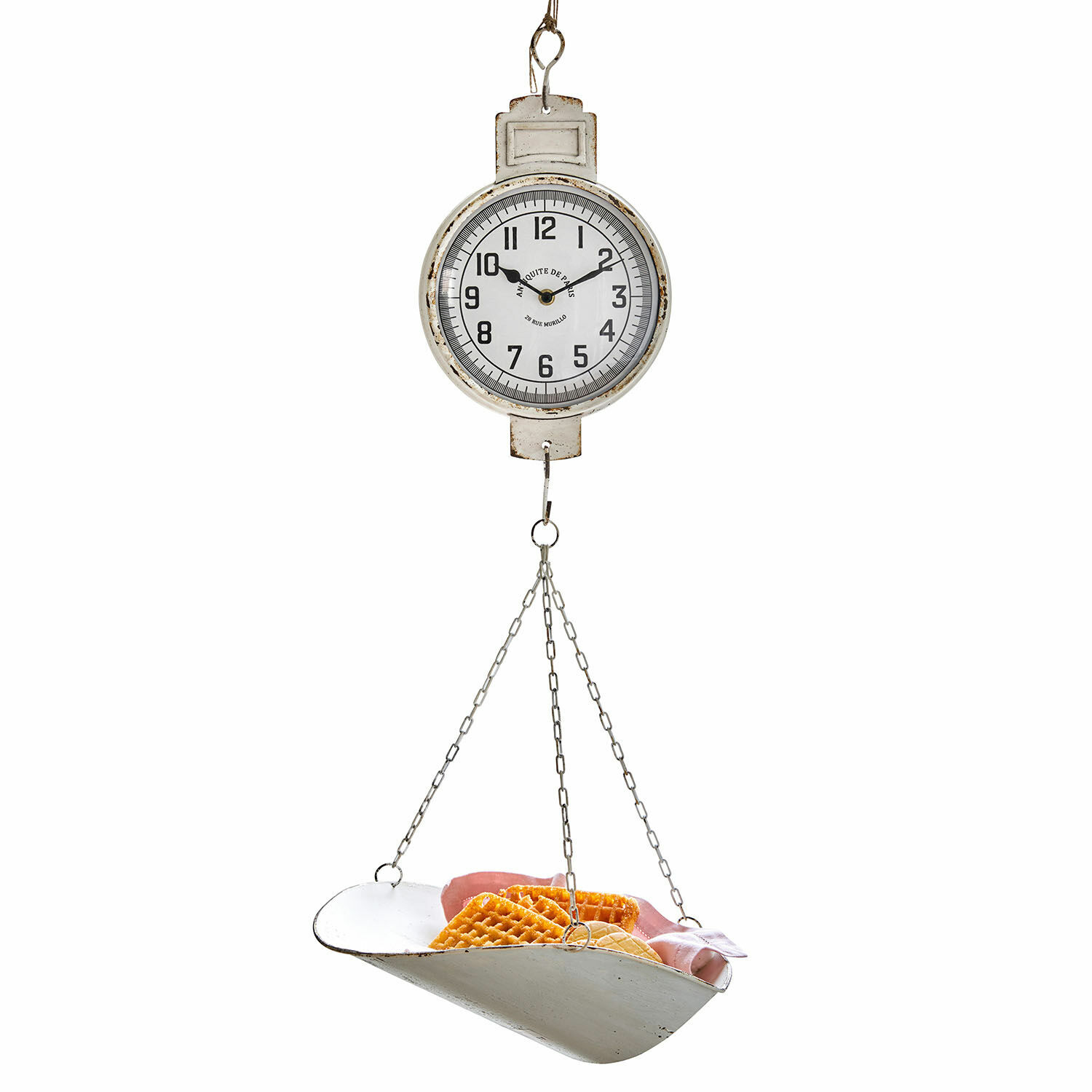 Weiße hängende Metallwaage mit Uhrzifferblatt und Kette, mit Waffeln und Schinken auf der Waagschale