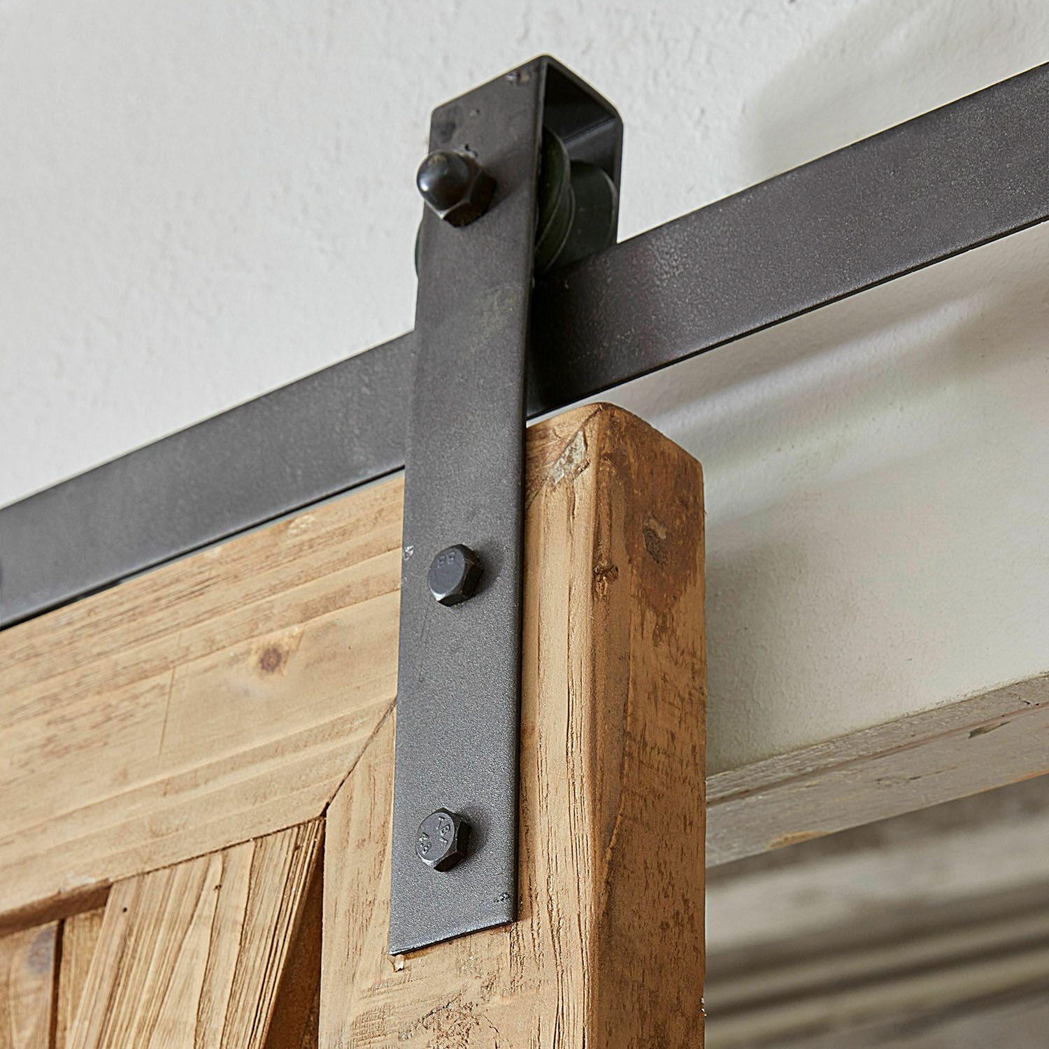 Schwarze Metallhalterung und Laufschiene für Schiebetür aus naturbelassenem Eichenholz