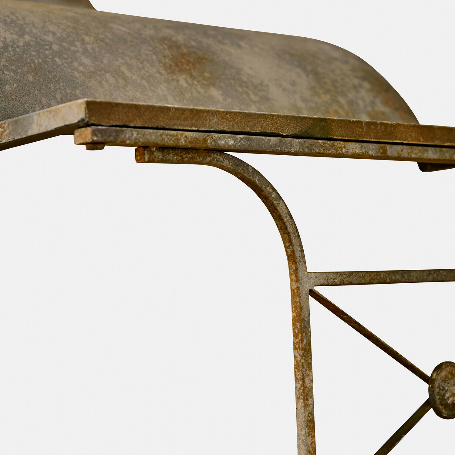 Metalltisch mit rostiger Patina und dekorativem Muster am Bein