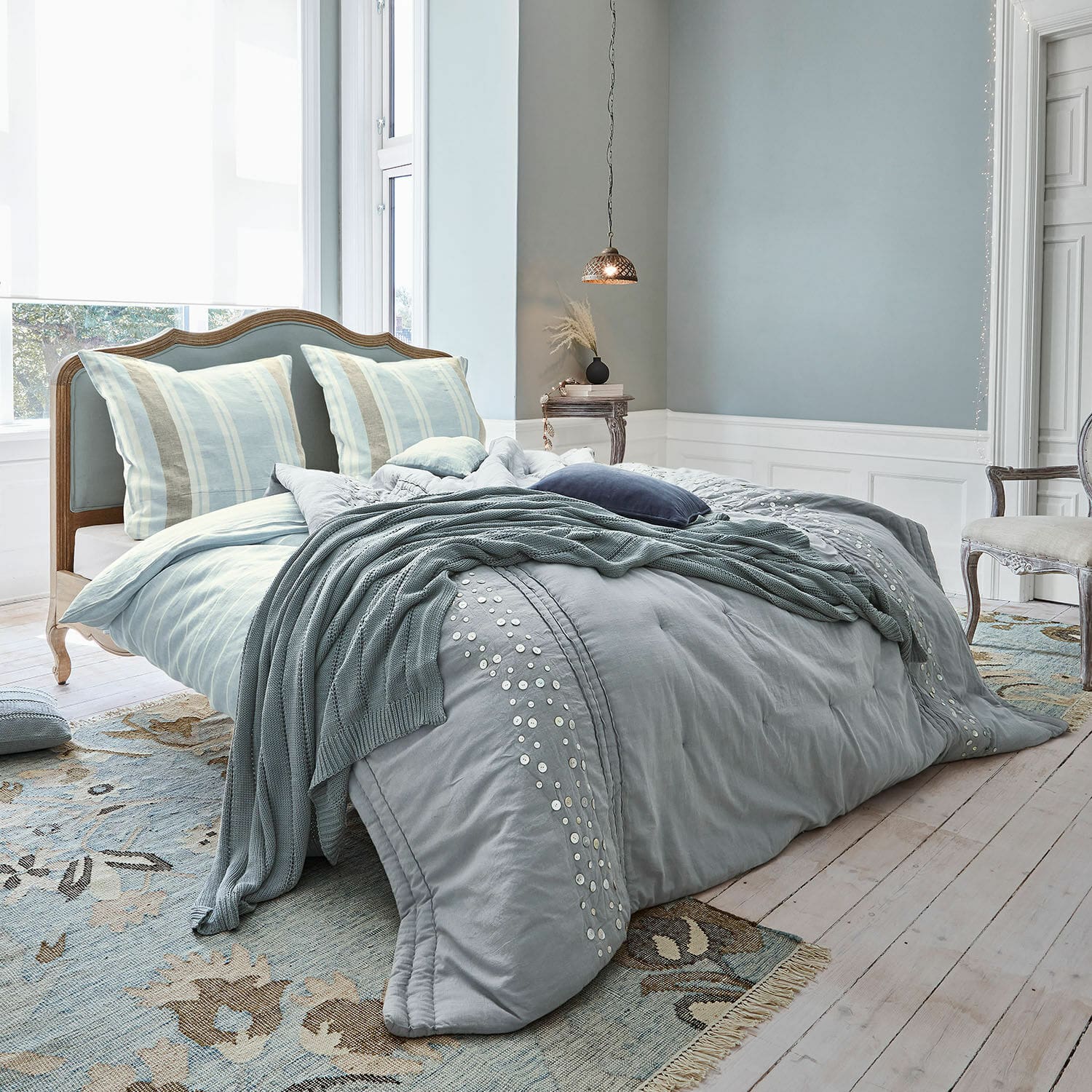 Bett Serravalle Schlafzimmer mit blauem Bett, Baumwollbettwäsche mit dekorativen Knöpfen und passender Decke