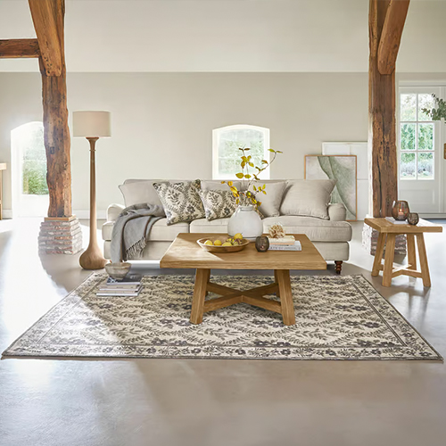 Gemütliches Wohnzimmer mit beigem Sofa, Holztisch und Teppich mit geometrischem Muster, natürliche Holzakzente