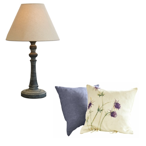 Tischlampe mit beigem Lampenschirm und zwei dekorative Leinenkissen in Grau und Creme mit Blumenmuster