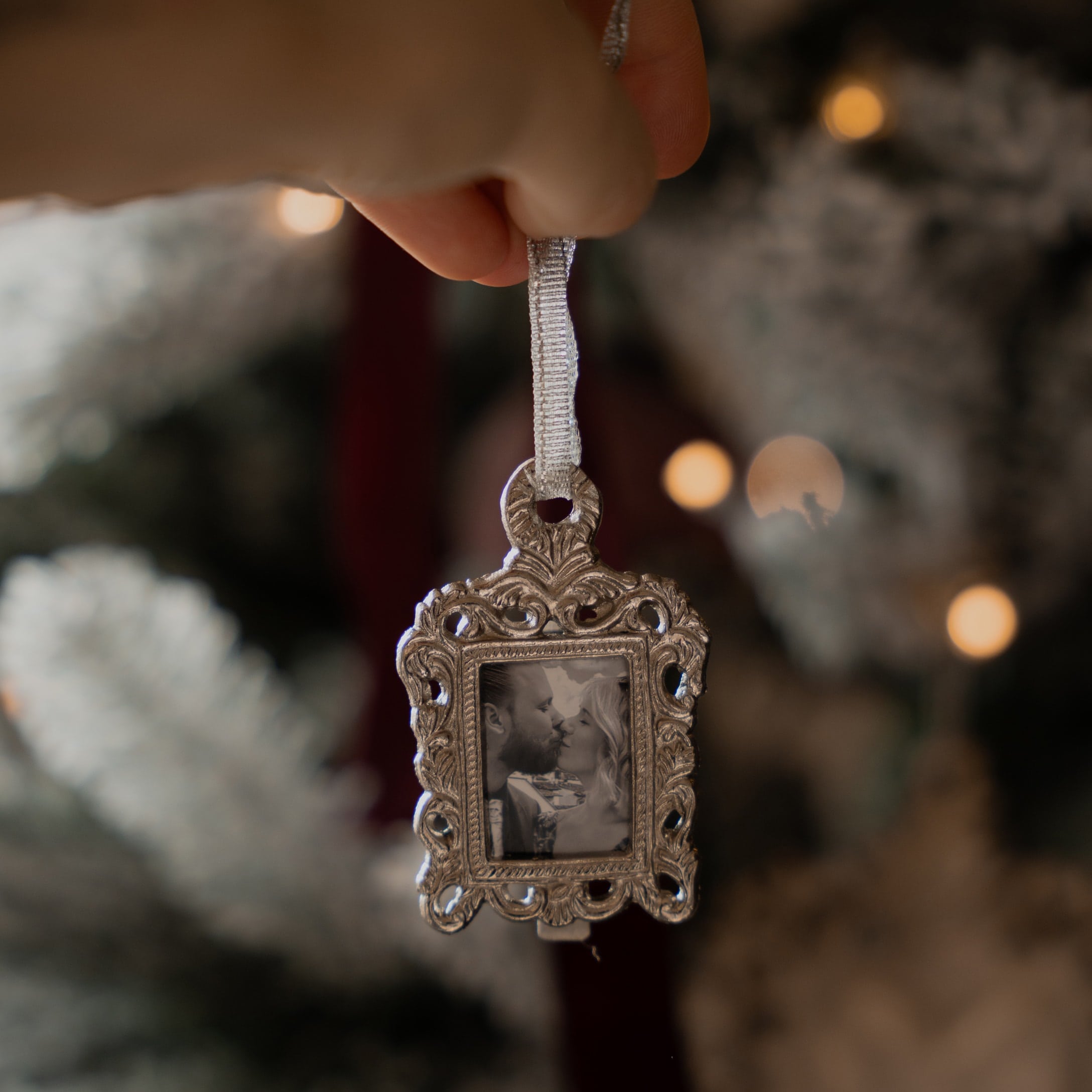 Weihnachtsschmuck mit silberner Metallrahmen und Schwarz-Weiß-Foto eines sich küssenden Paares