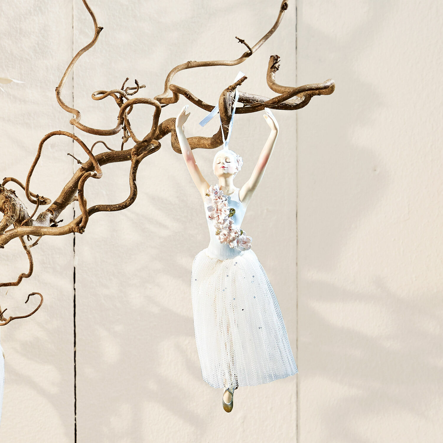 Ballerina-Dekoration aus Stoff und Kunststoff in weißem Kleid mit Blumen, an Ast hängend