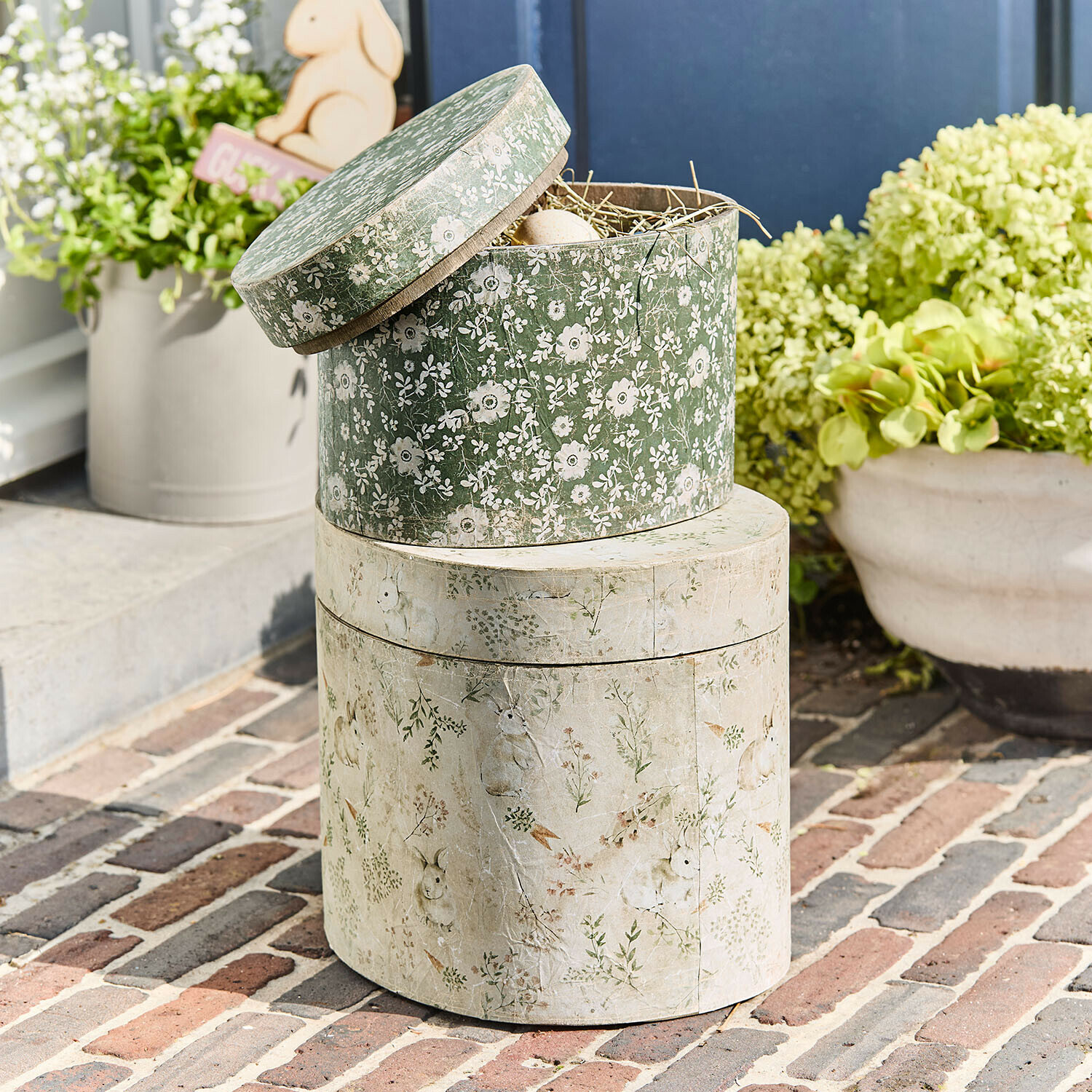 Dekorative Papierboxen mit grünen und cremefarbenen Blumen- und Hasenmotiven, Frühlingsdeko