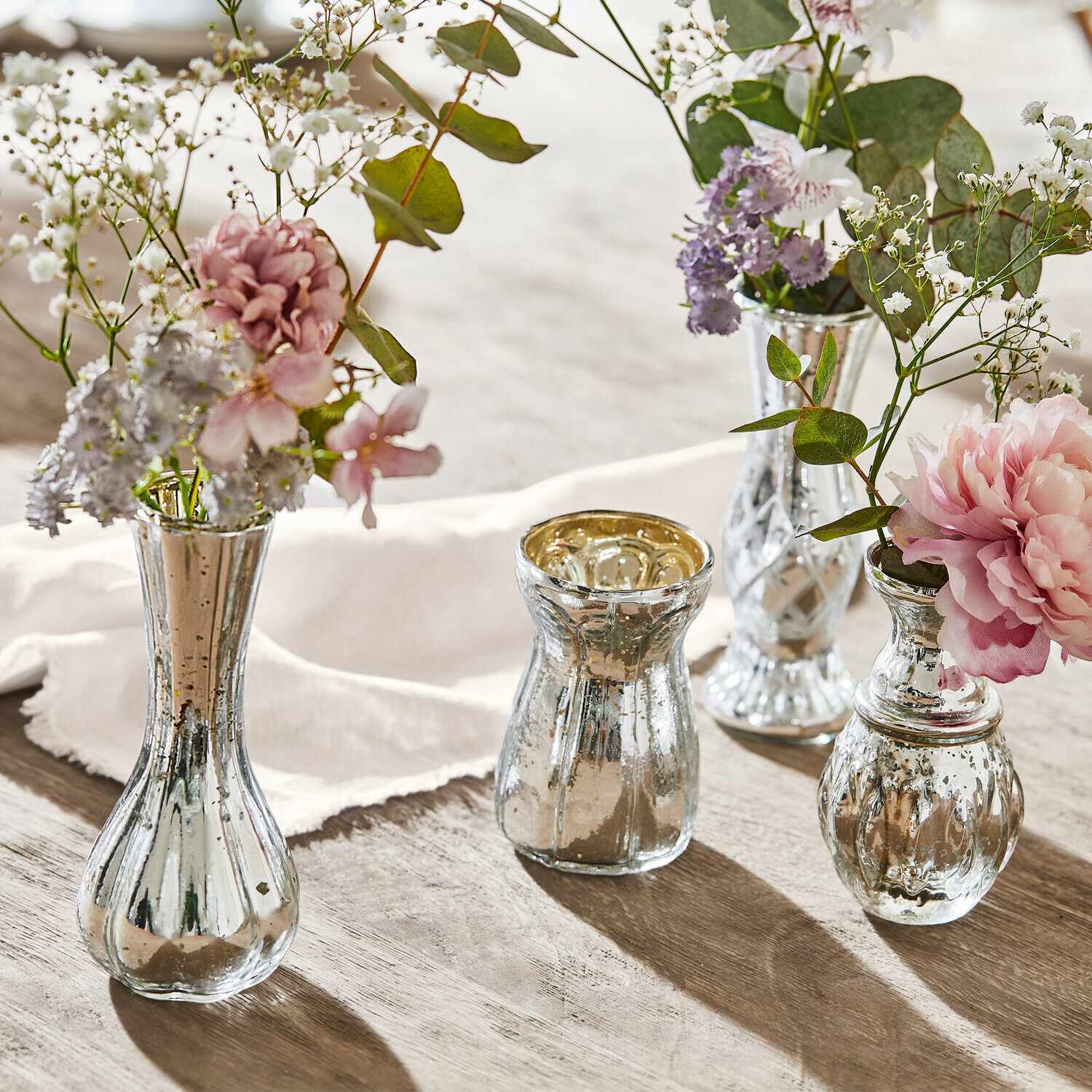 Deko-Vase 4er Set Maelie Vier silberne Glasvasen mit Blumen auf Holztisch, stilvolle Tischdekoration im Vintage-Stil