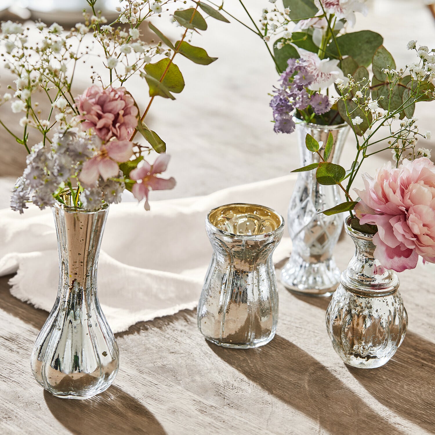 Deko-Vase 4er Set Maelie Vier silberne Glasvasen mit Blumen auf Holztisch, stilvolle Tischdekoration im Vintage-Stil
