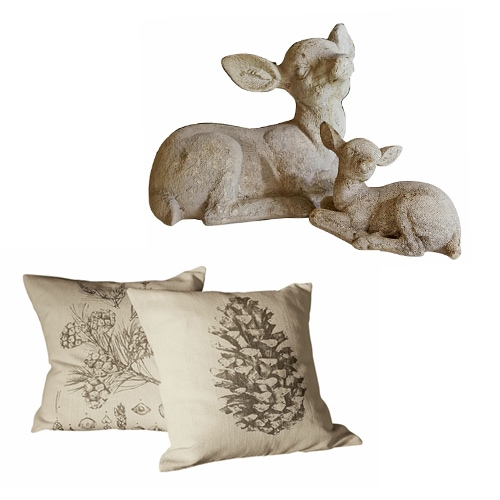 Dekoration mit zwei beigen Kissen mit Zapfen- und Blumenmotiv und einer Steinfigur von zwei Rehen
