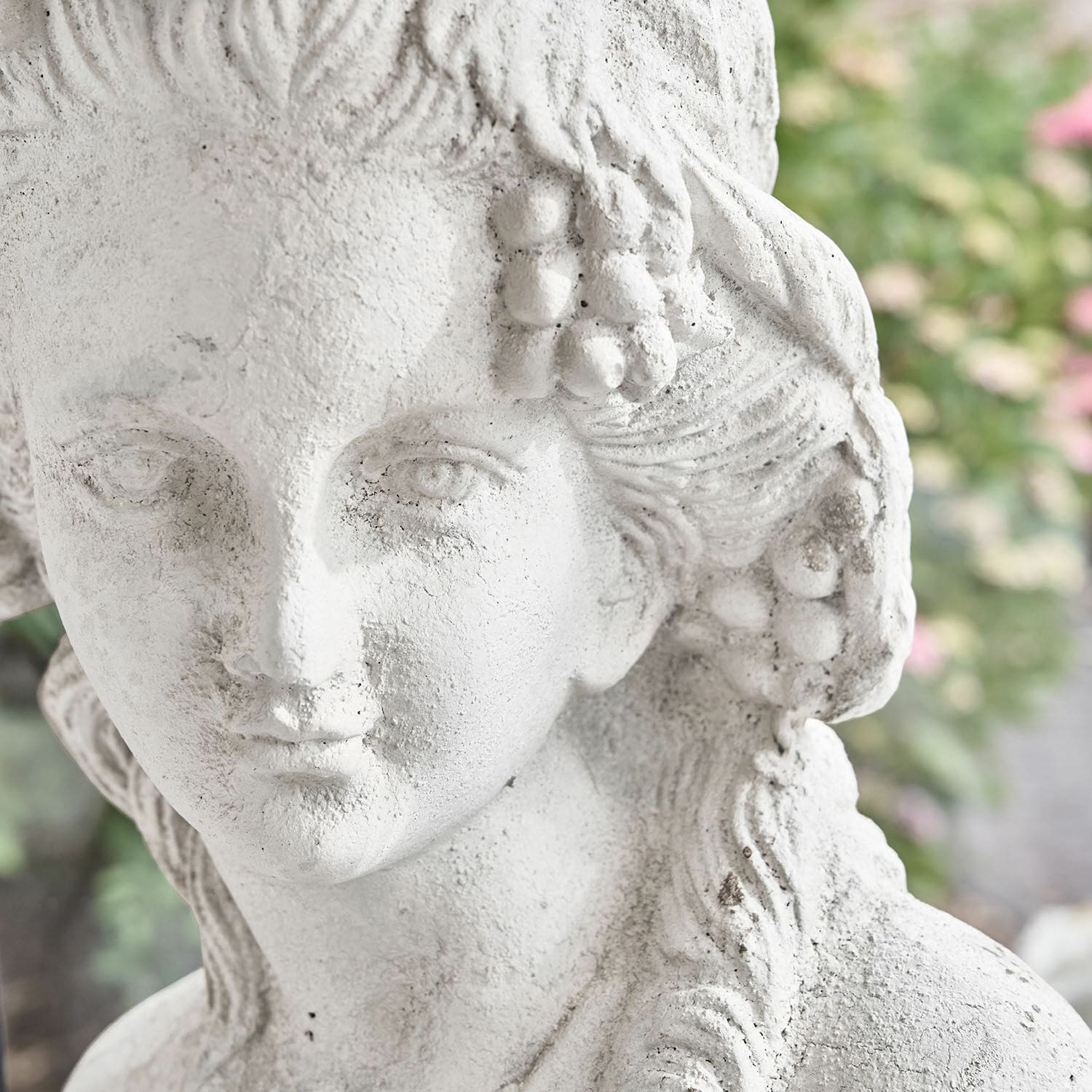 Weiße Steinskulptur einer Frau mit Trauben und detaillierten welligen Haaren