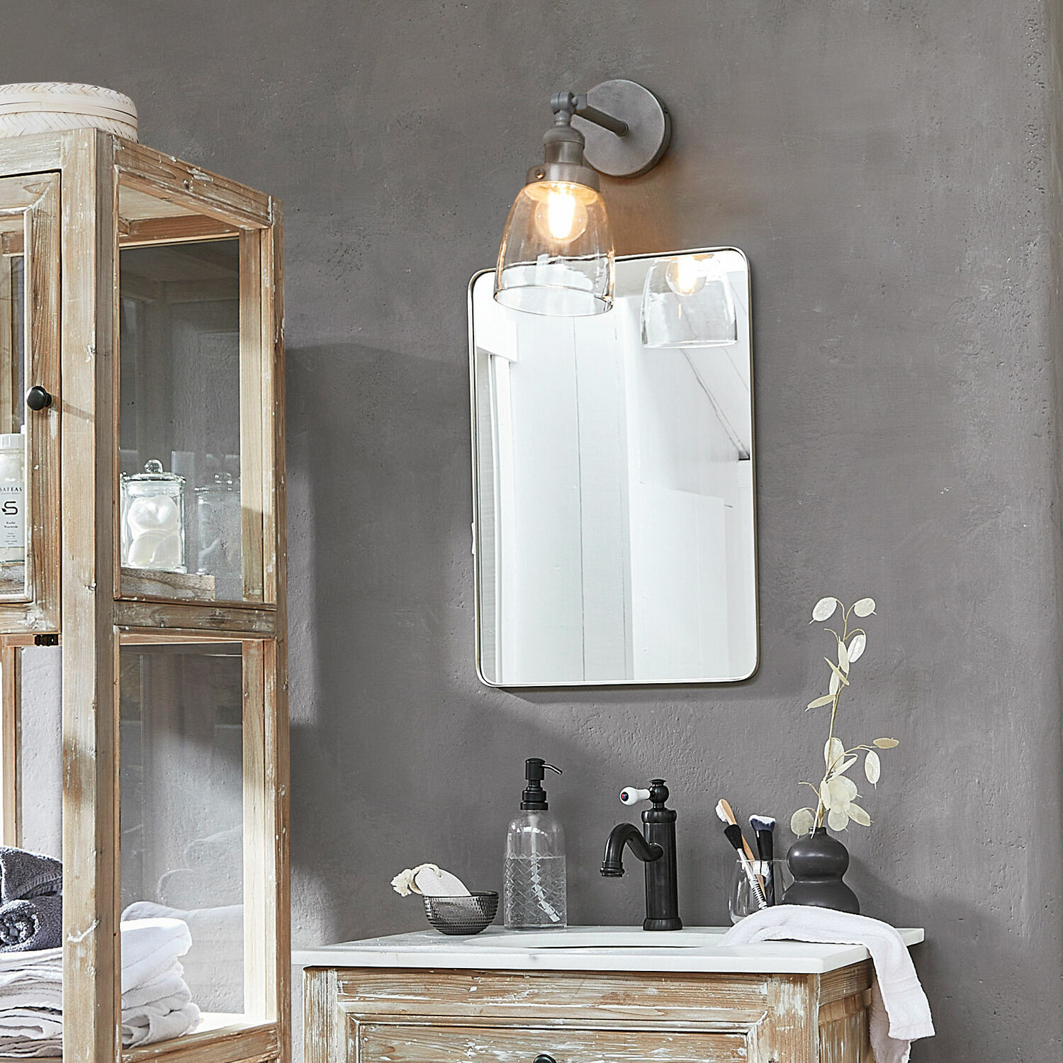 Rustikaler Holz-Badezimmerschrank mit weißer Arbeitsplatte und schwarzem Wasserhahn an grauer Wand