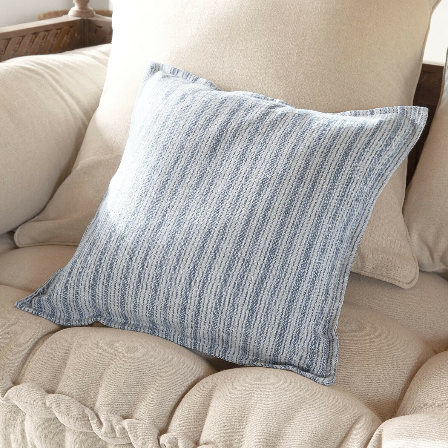 Kissenhülle Freydaal Dekoratives Baumwollkissen mit blau-weißen Streifen auf beigem Sofa, stilvolles Wohnaccessoire