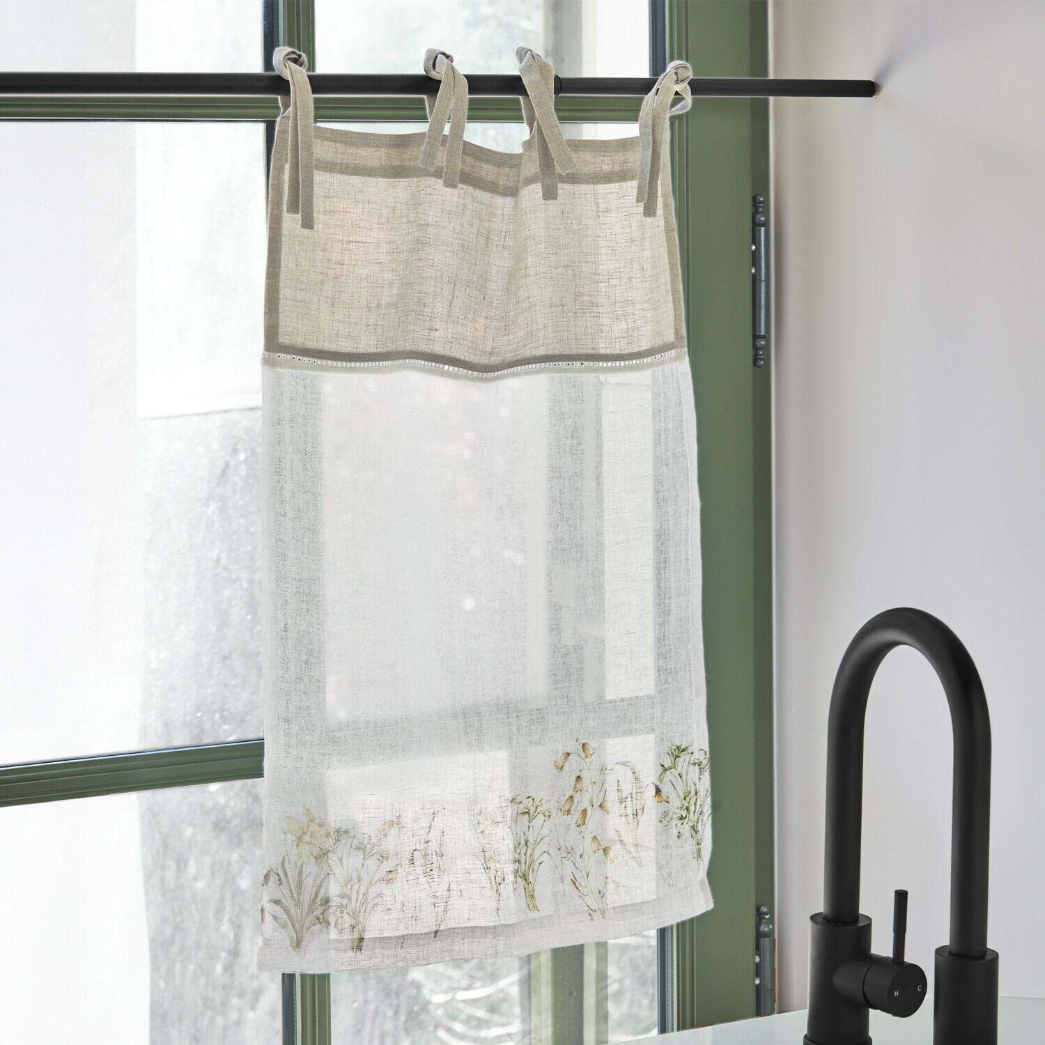 Scheibengardine Lozere Leinenvorhang in Beige und Weiß mit zartem Blumenmuster, an schwarzer Stange neben schwarzem Wasserhahn