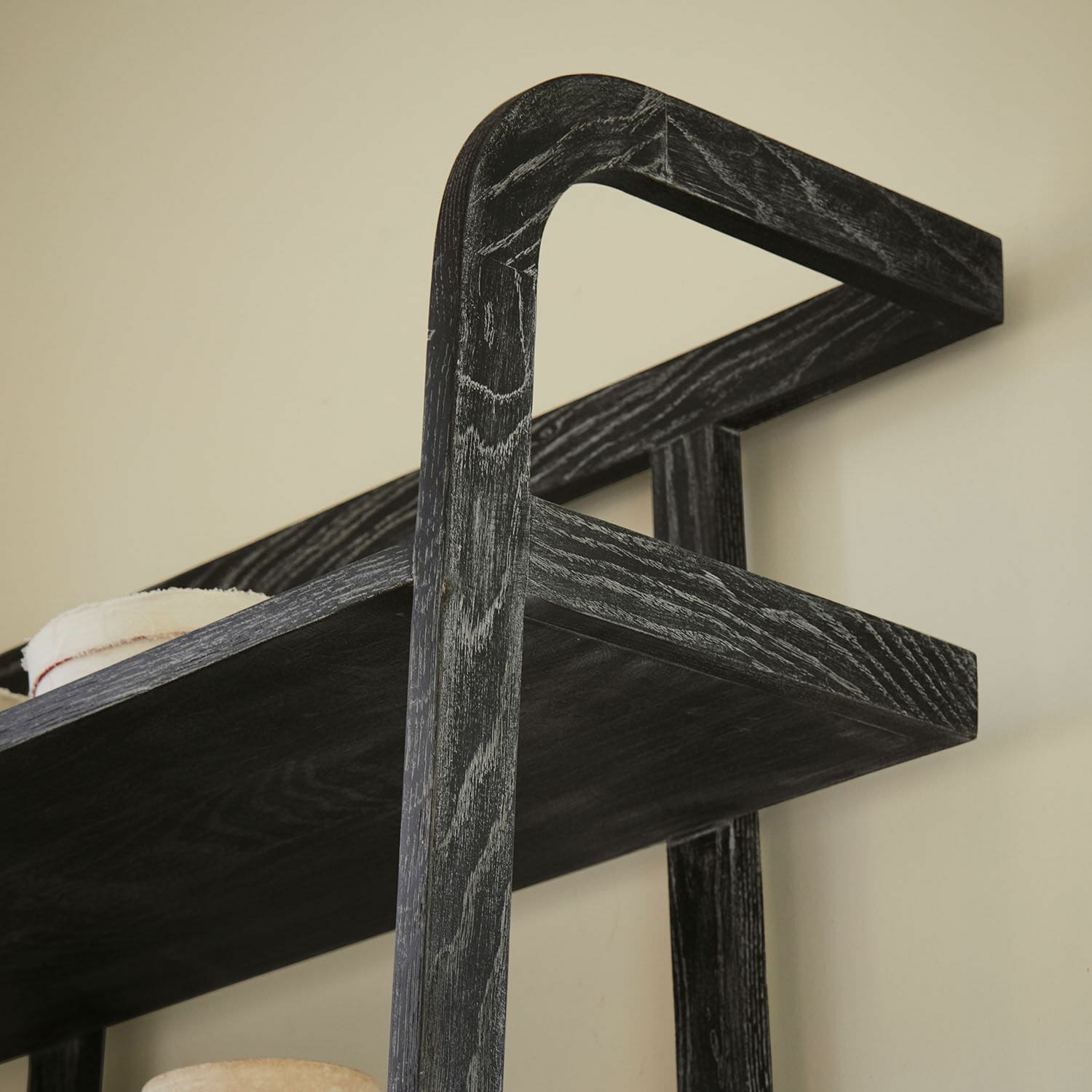 Schwarzes Holz-Wandregal mit sichtbarer Maserung zur Aufbewahrung von Dekoration und Büchern