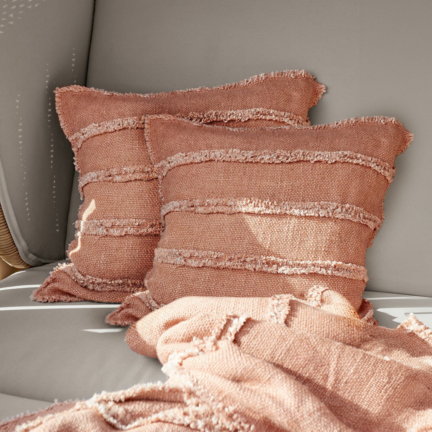 Kissenhülle 2er Set Allanton Rosa dekorative Kissen und weiche Decke aus Stoff auf grauem Sofa im Wohnzimmer