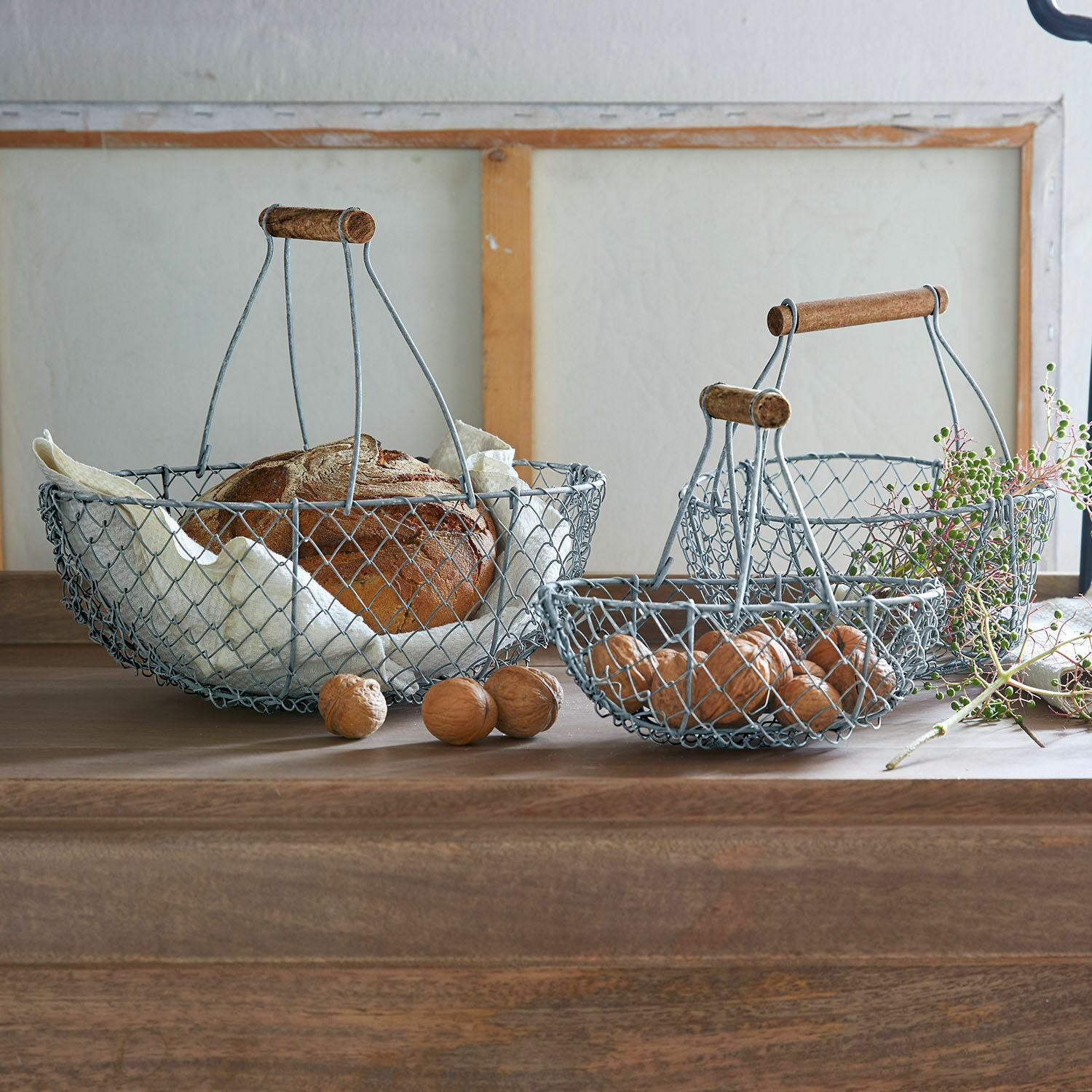 Drahtkorb 3er Set Baker Drei vintage Metallkörbe mit Holzgriffen für Brot und Nüsse auf Holztisch