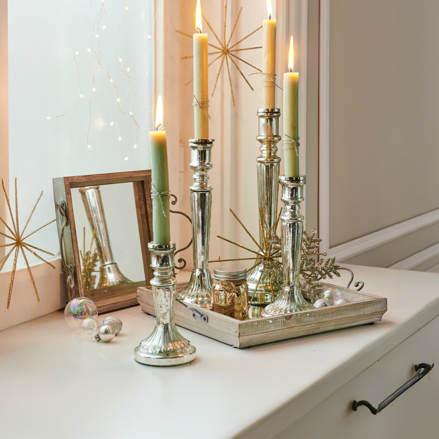 Kerzenständer 4er Set Selby Silberne Metall-Kerzenhalter mit grünen und cremefarbenen Kerzen auf dekorativem Holztablett