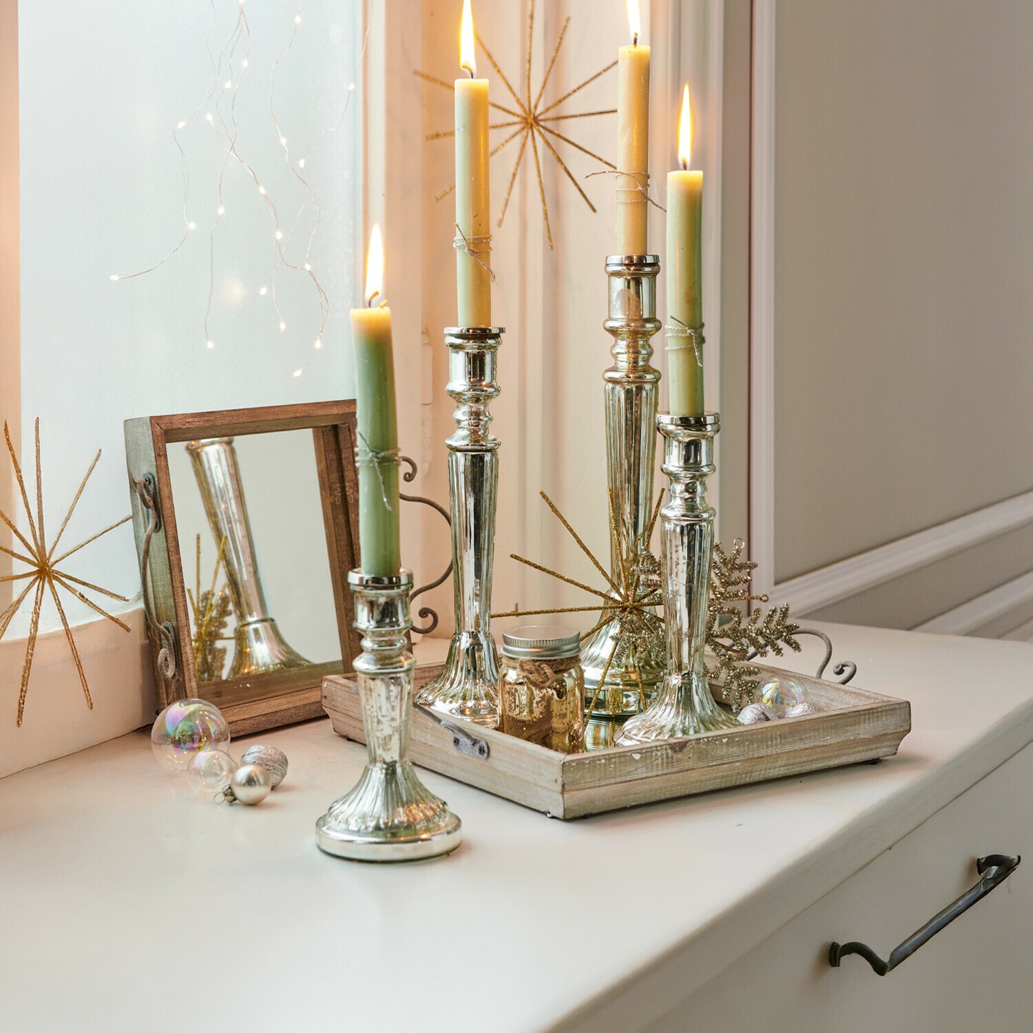 Kerzenständer 4er Set Selby Silberne Metall-Kerzenhalter mit grünen und cremefarbenen Kerzen auf dekorativem Holztablett