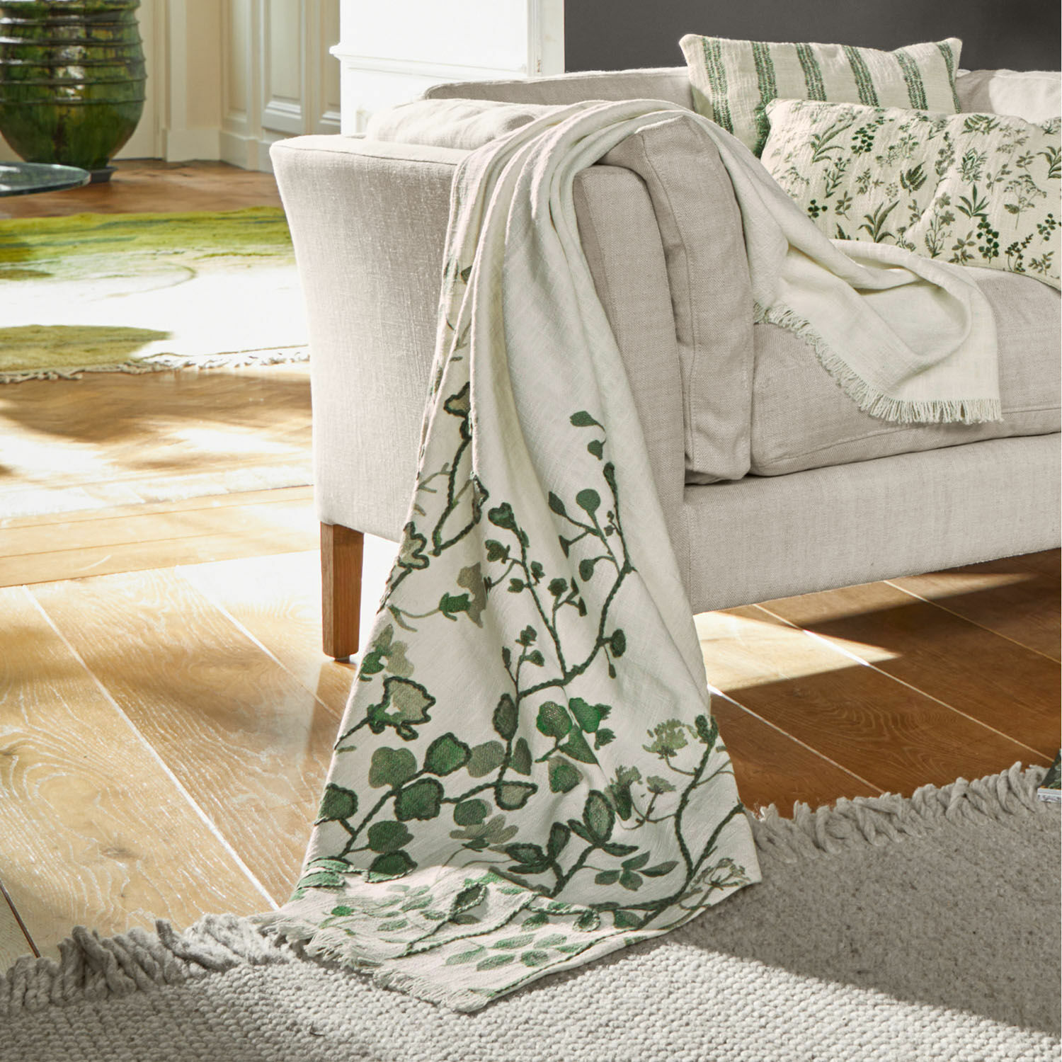 Plaid Wescombe Beige Decke mit grünem Pflanzenmuster auf Sofa, weiches Material, gemütliche Wohnraumdeko
