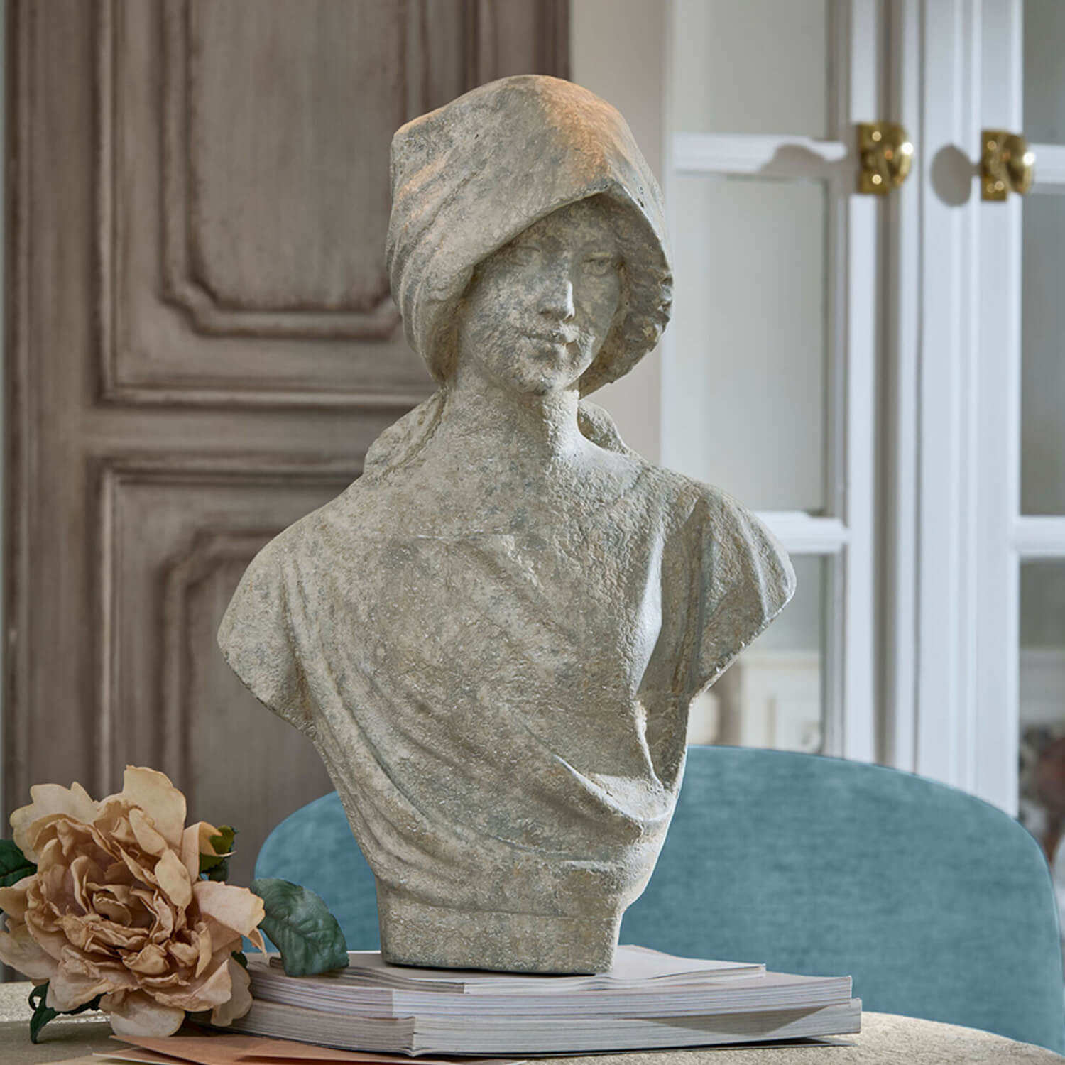 Graue Steinstatue einer Frau als Büste auf einem Buchstapel mit Blume, elegante Wohnraumdekoration