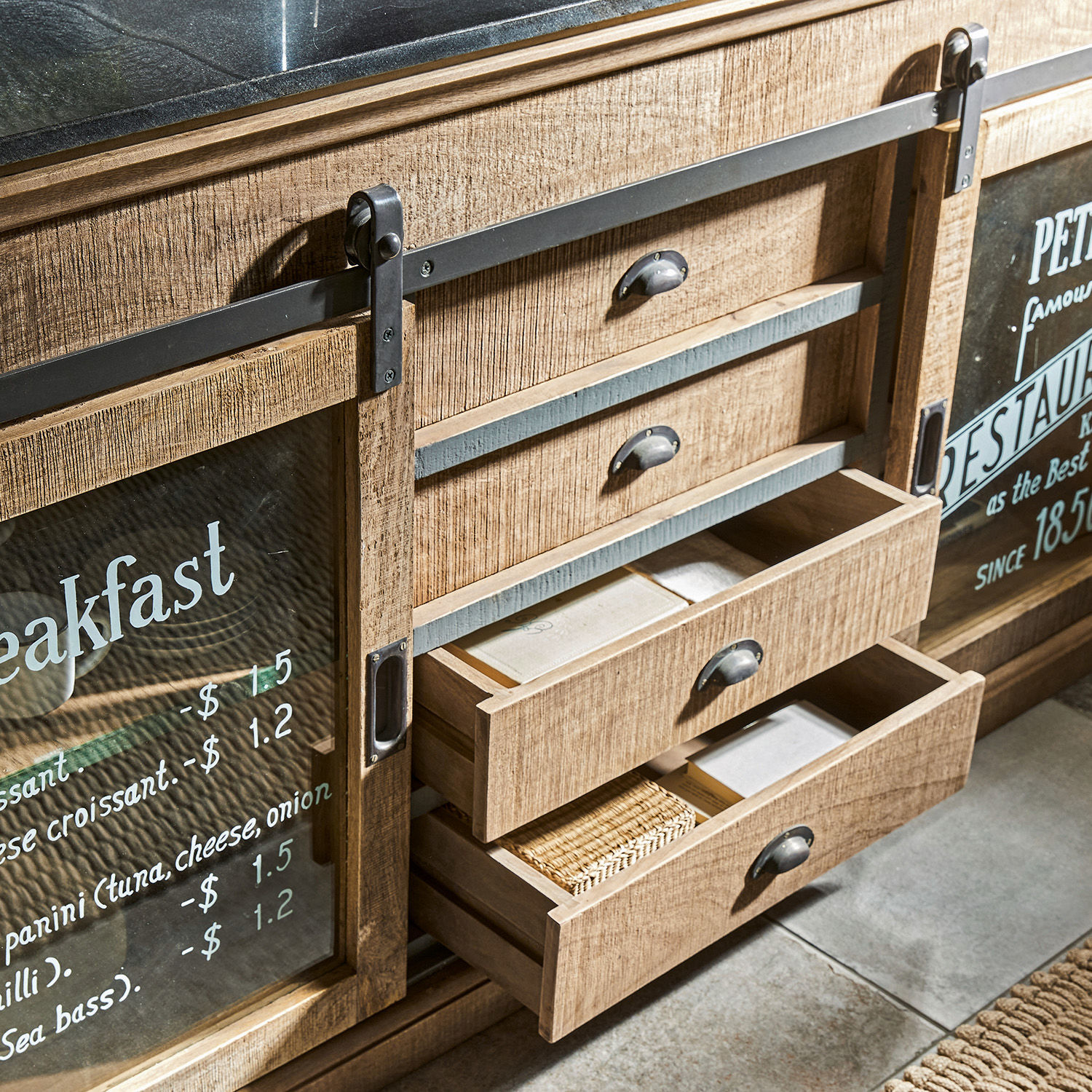 Küchenschrank aus hellem Holz mit Metallgriffen und Glastüren mit aufgedruckter Frühstückskarte