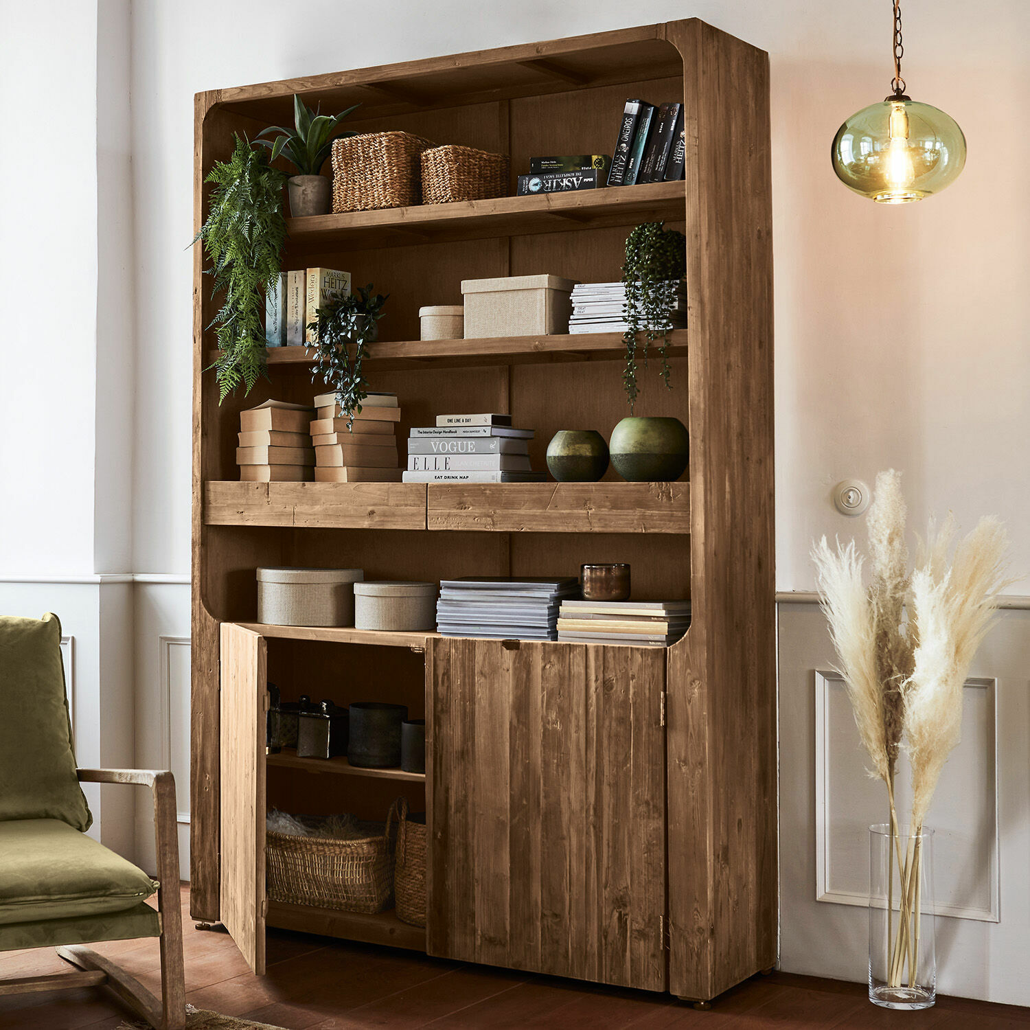 Massives Holzregal mit offenen Fächern und Türen, dekoriert mit Büchern und Pflanzen in Naturfarbe
