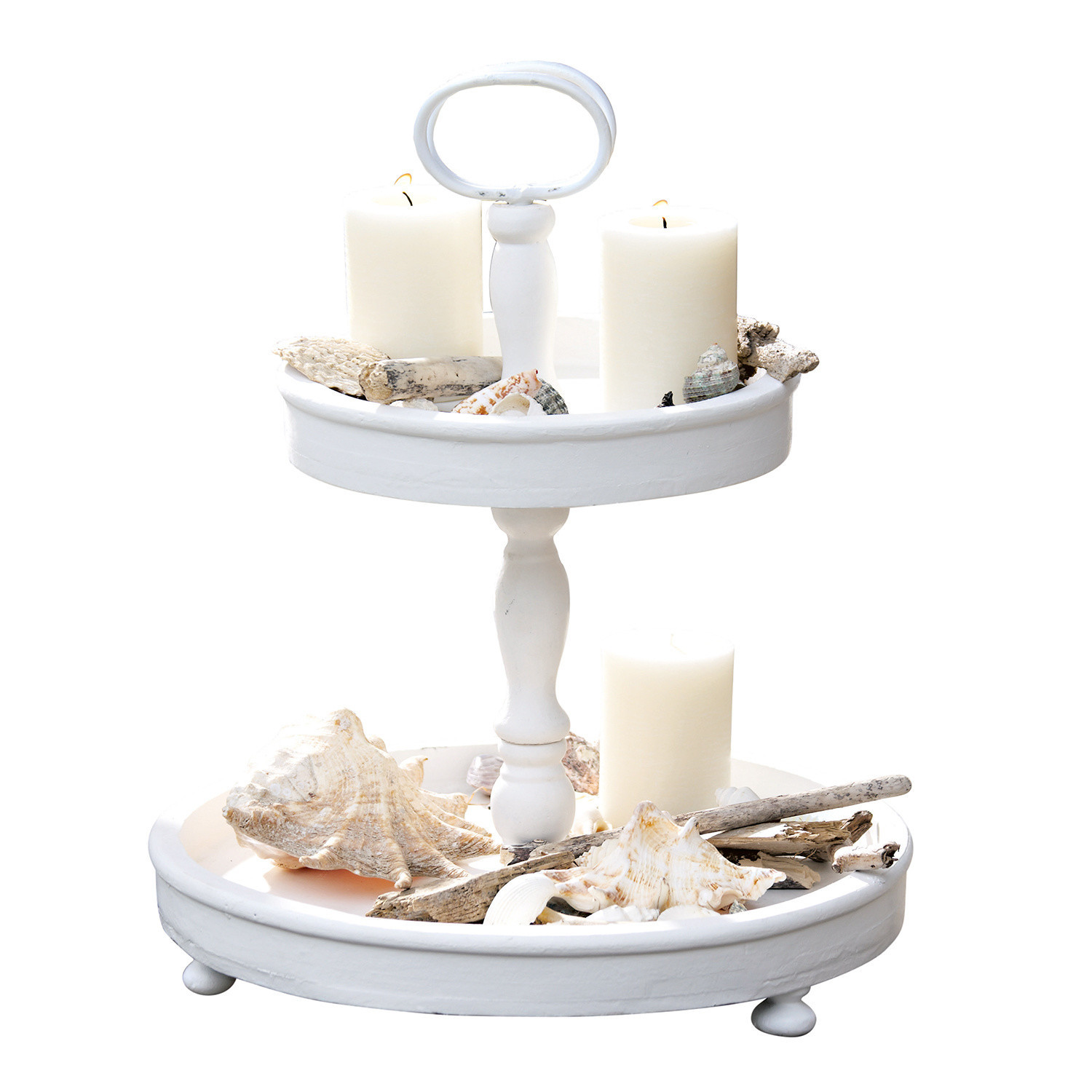 Zweistöckiges weißes Holztablett mit weißen Kerzen und dekorativen Muscheln auf Tisch