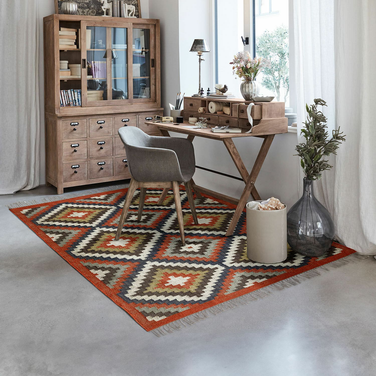Teppich Dailies Geometrisch gemusterter Teppich in warmen Farben in modernem Arbeitszimmer mit Holzschreibtisch und Schrank