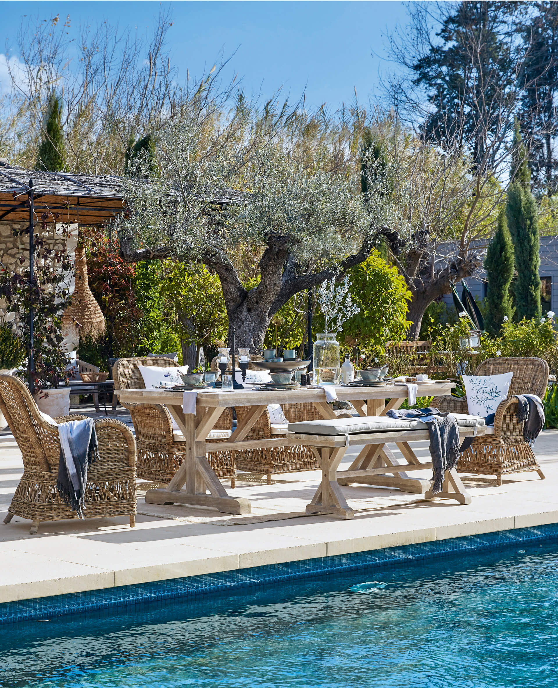 Gartenmöbel-Set aus Holz und Rattan in Naturtönen am Pool auf der Terrasse