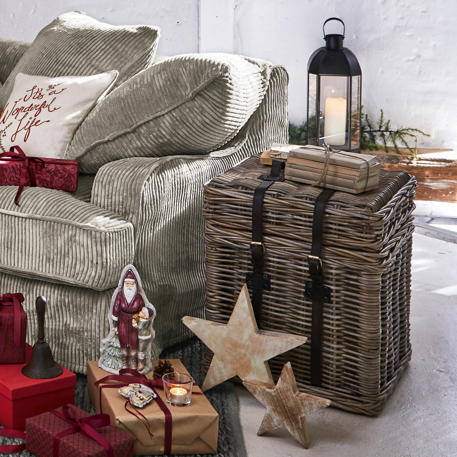 Beiges Cord-Sofa neben einem Korbtruhe aus Rattan und weihnachtlicher Dekoration im Wohnzimmer