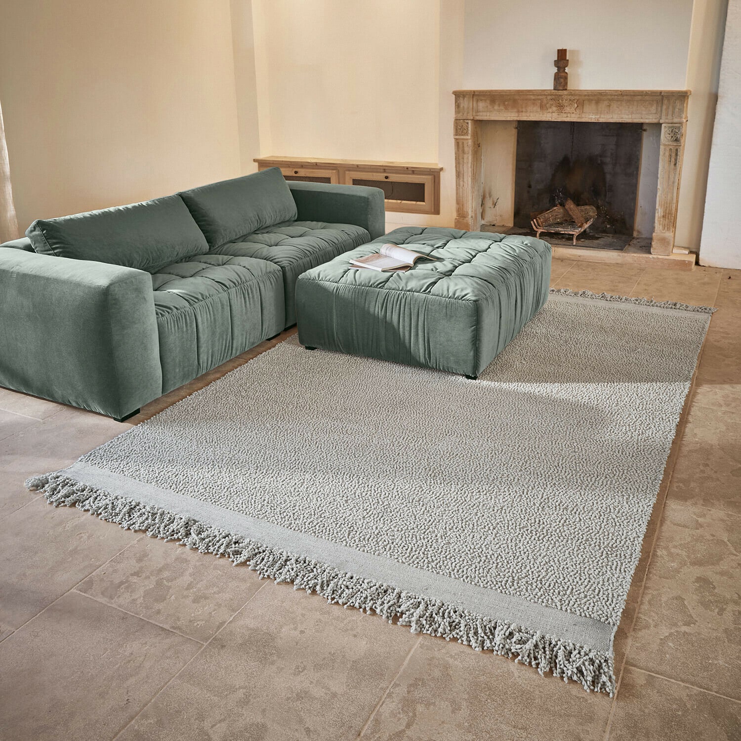 Teppich Linnet Mintgrünes Sofa und Polster aus weichem Stoff auf hellem Teppich mit Fransen im Wohnzimmer mit Kamin