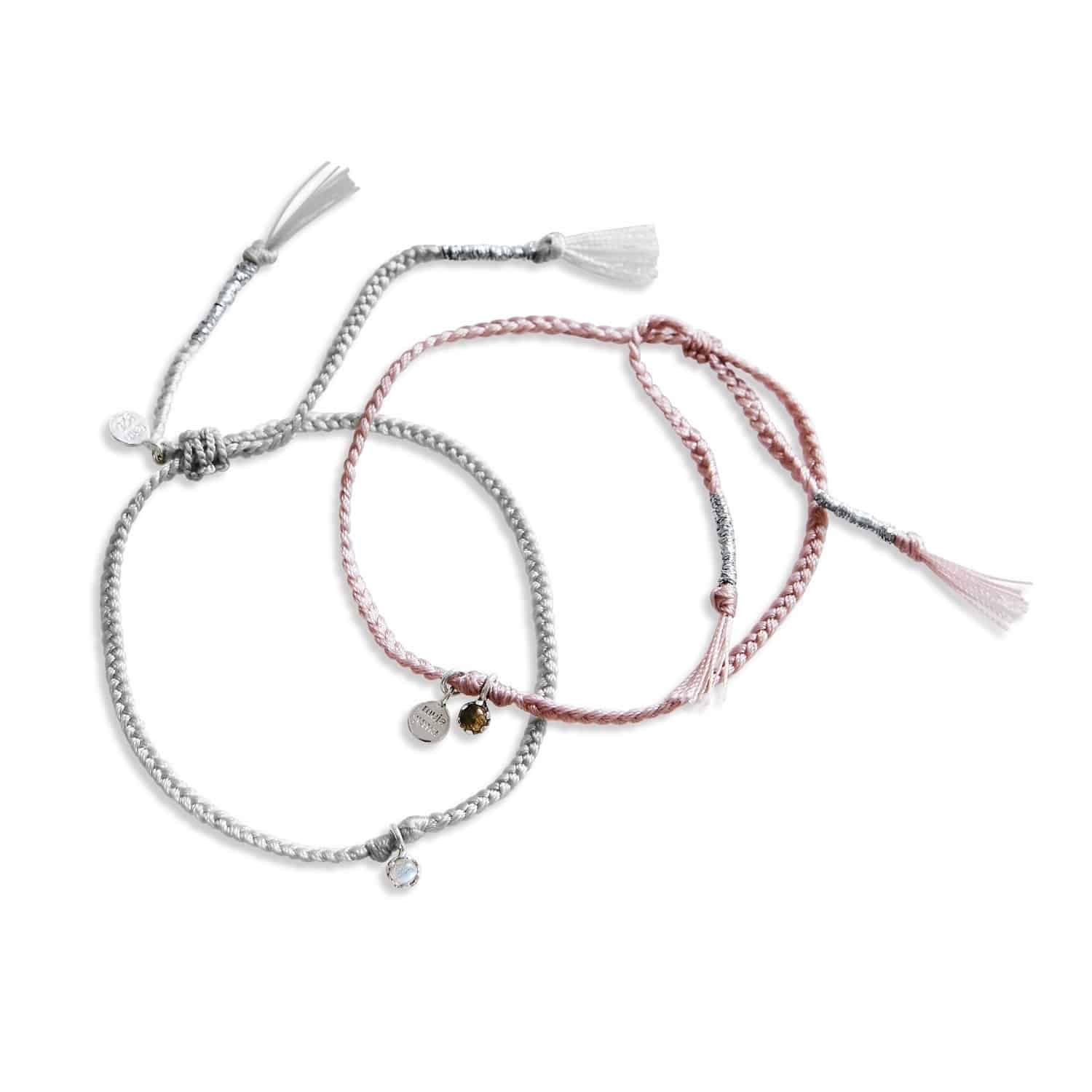 Set aus zwei geflochtenen Armbändern mit dekorativen Anhängern in Rosa und Grau