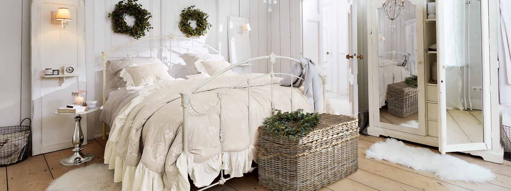 Schlafzimmer im Shabby-Chic-Stil mit weißem Metallbett und beiger Bettwäsche mit Rüschen