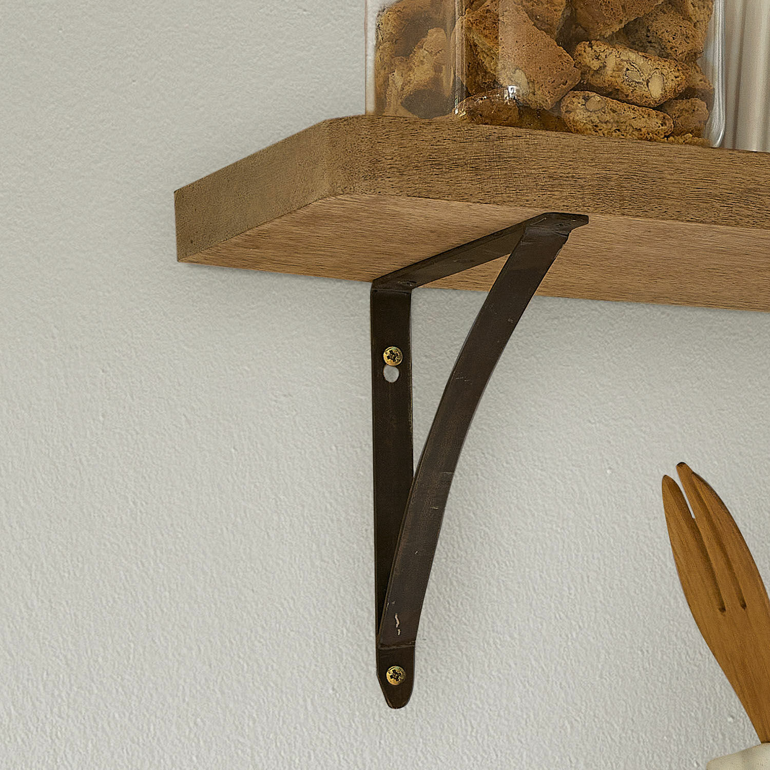 Schwarze Metall-Wandhalterung trägt Holzregal mit Keksdose für Küchenaufbewahrung