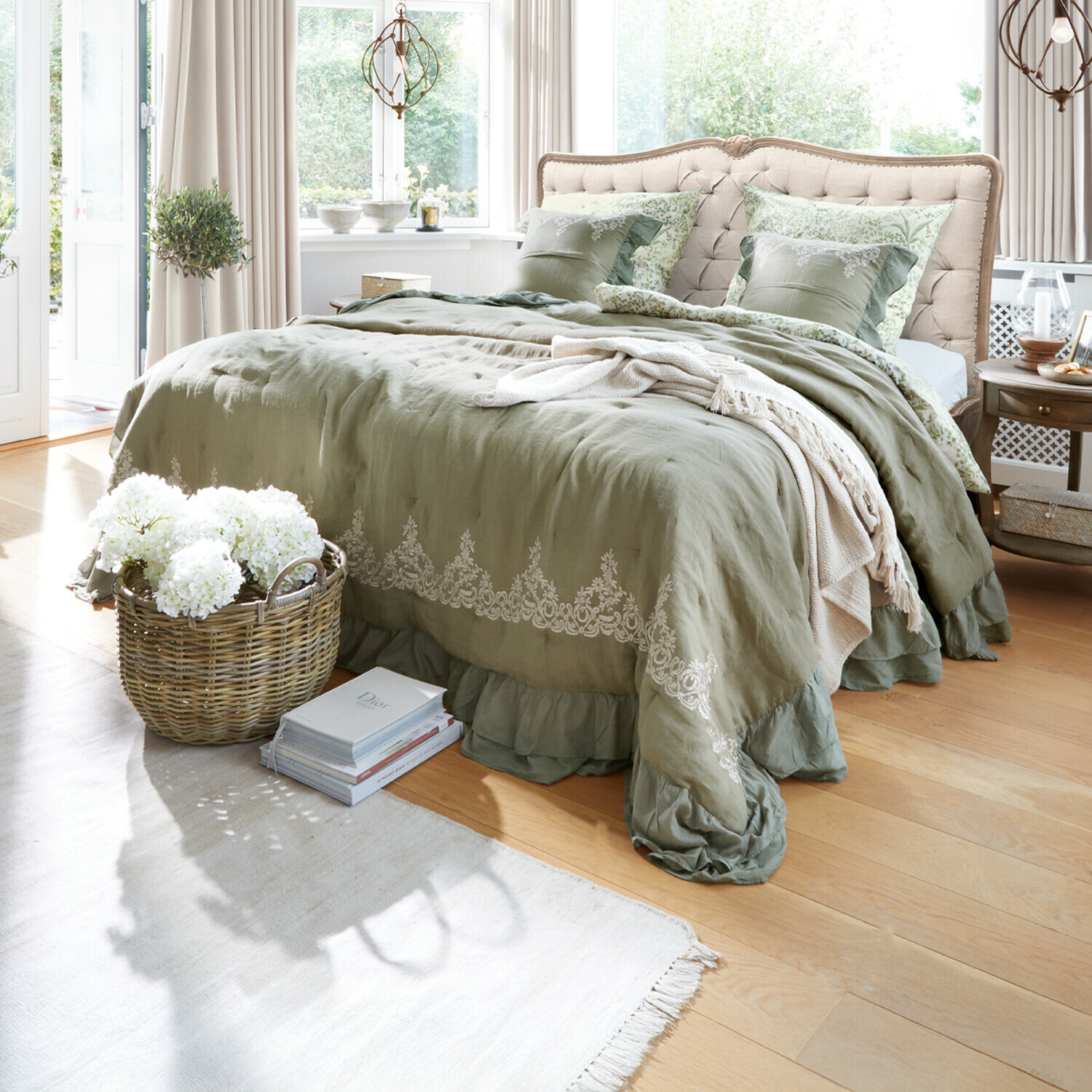 Quilt Therese Schlafzimmer mit beigem gepolstertem Kopfteil und grüner Leinenbettwäsche mit Stickerei
