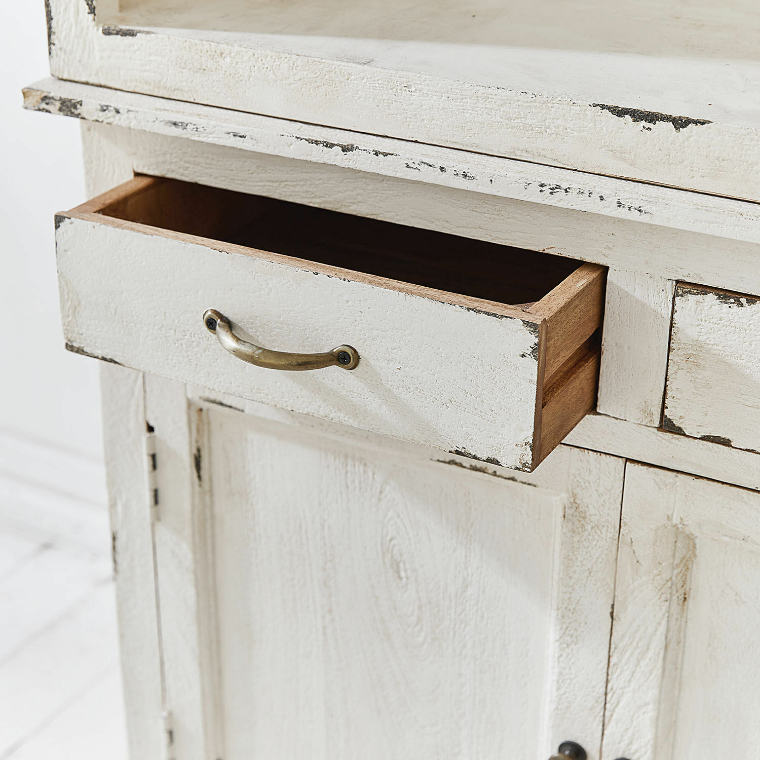 Weißes Holzmöbel mit geöffneter Schublade und Metallgriff im Vintage-Stil zur Aufbewahrung