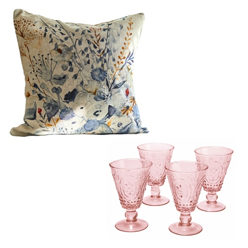 Dekoratives Kissen mit blau-braunem Blumenmuster und vier rosa Trinkgläser aus Glas