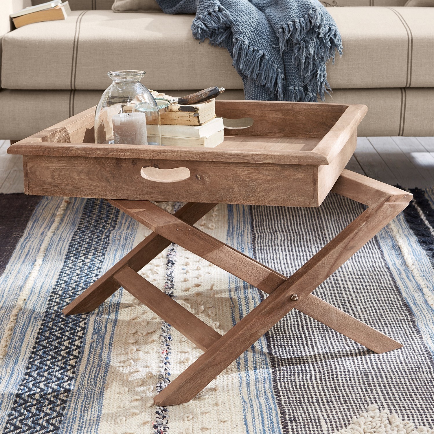 Beistelltisch aus Mangoholz in Natur mit Tablett und Dekoration auf Teppich im Wohnzimmer