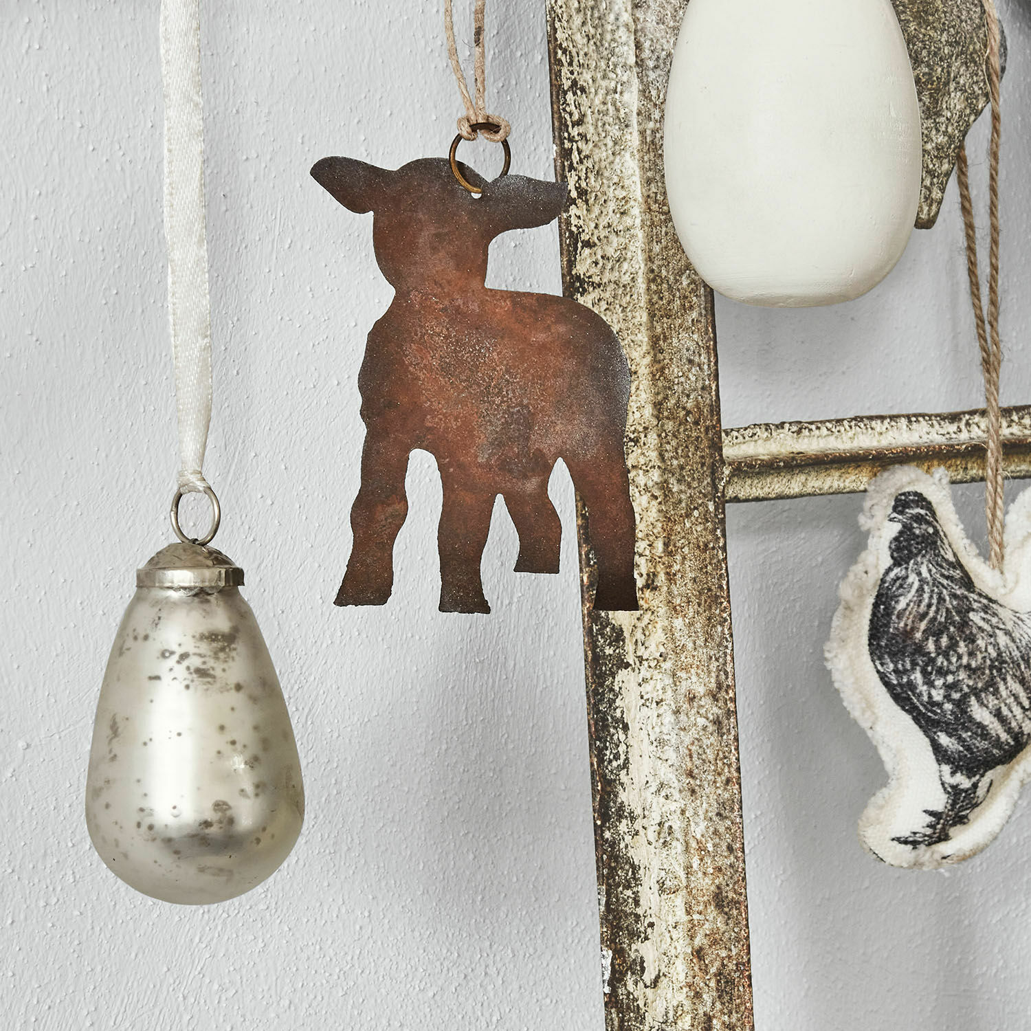 Rustikale Metall-Hängedekoration in Tierform mit weiteren Vintage-Anhängern aus Glas und Stoff